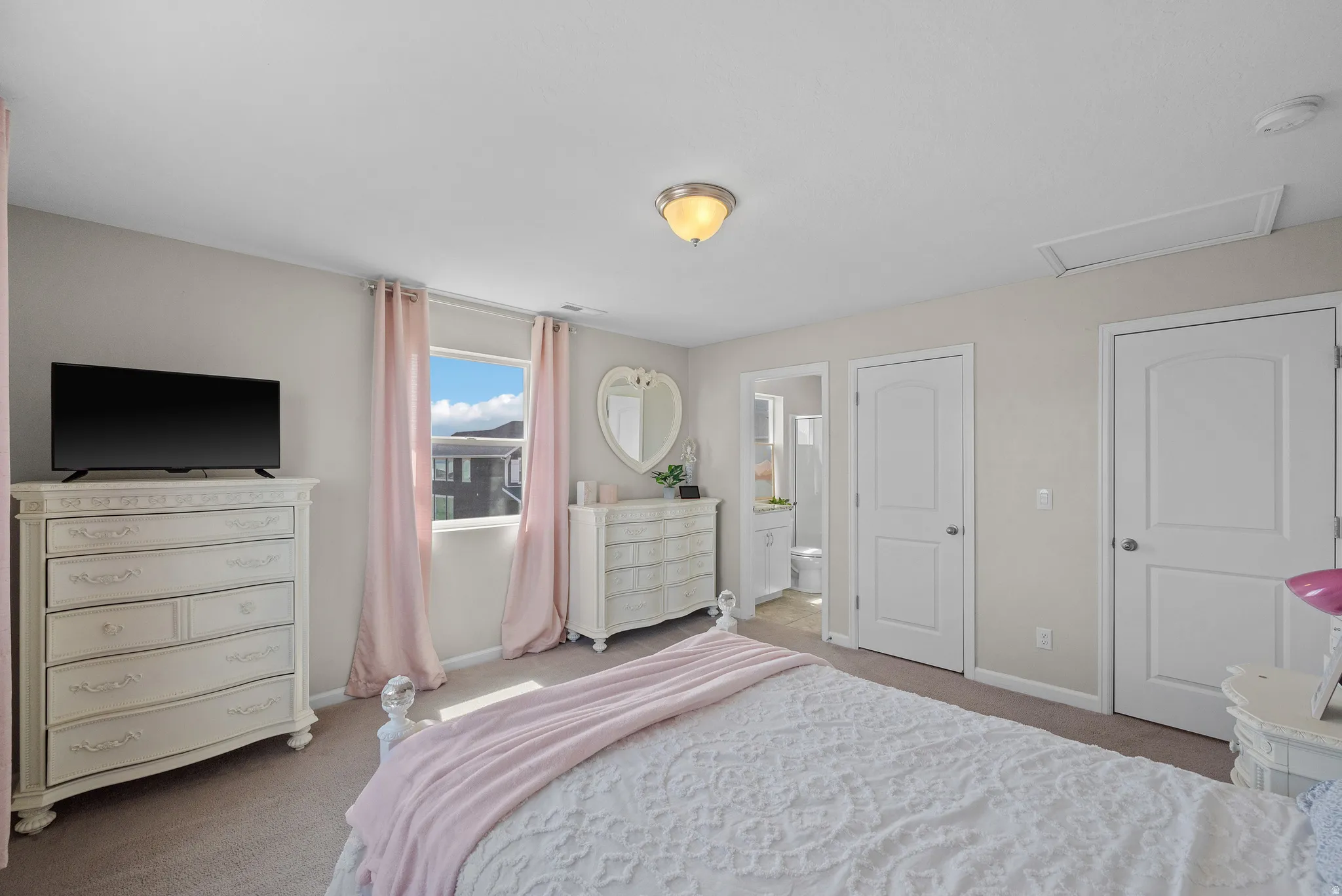 Ensuite Bedroom featuring light colored carpet and ensuite bathroom