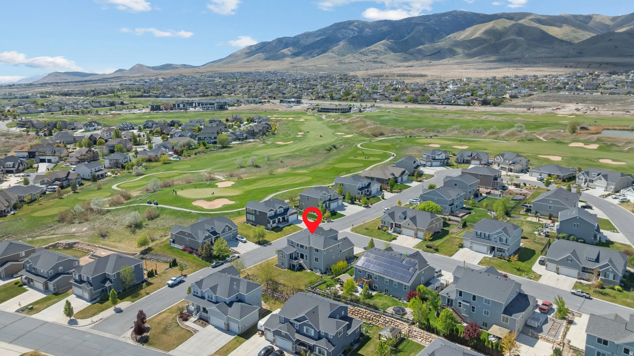 Aerial perspective of suburban area with mountains and a local golf course