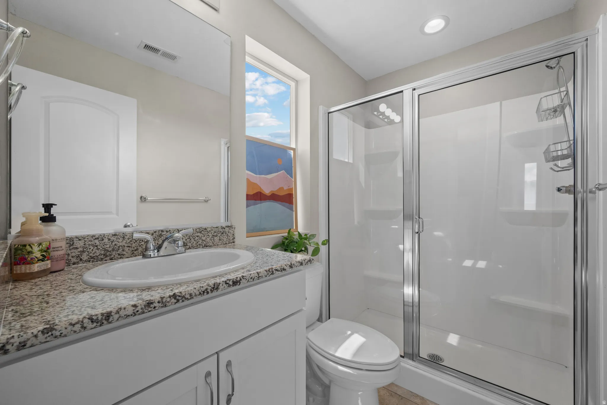 Ensuite bathroom featuring vanity and a stall shower