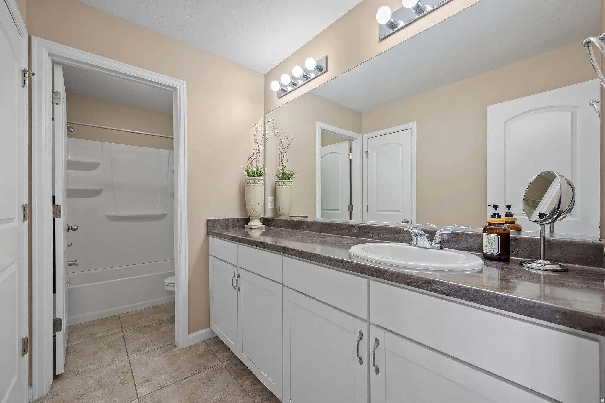 Full bathroom featuring vanity, light tile patterned floors, and shower / bathtub combination