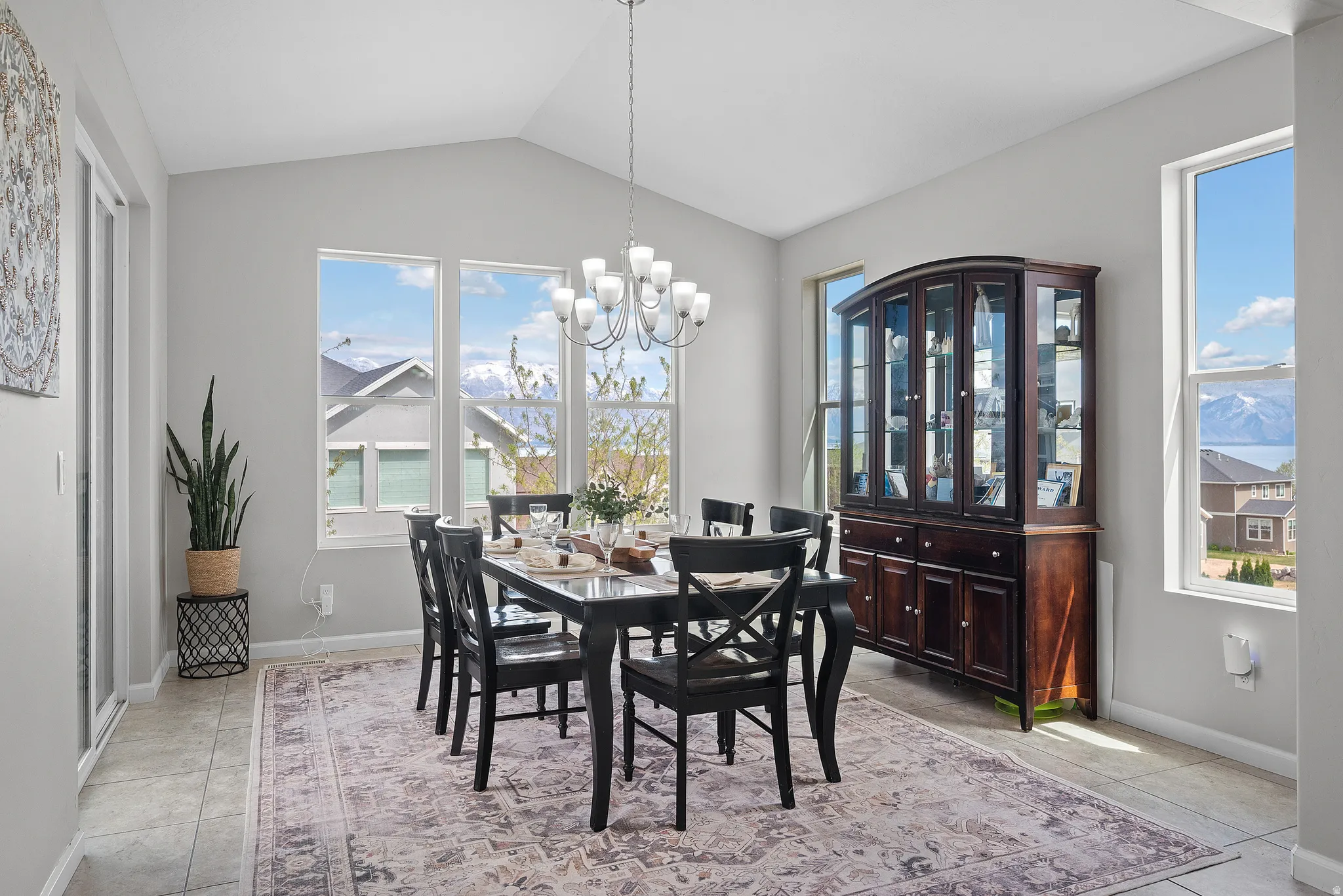 Dining room featuring lofted ceiling, suspended lighting, and light tile patterned floors