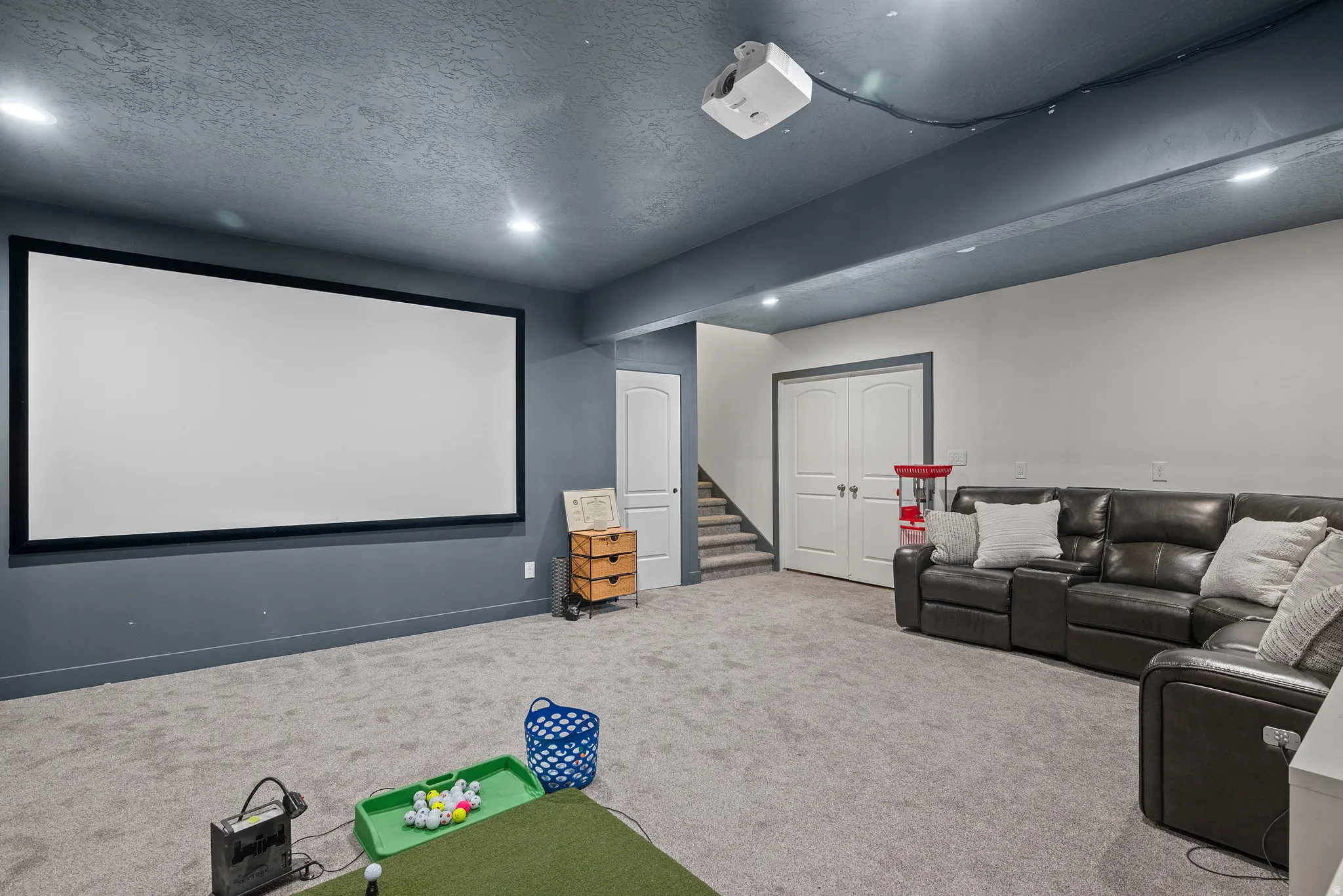 Theater room featuring a textured ceiling and recessed lighting, set up for golf sim and future wet bar