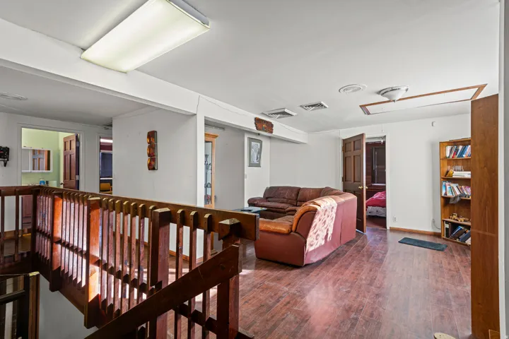 Living area featuring attic access and wood finished floors