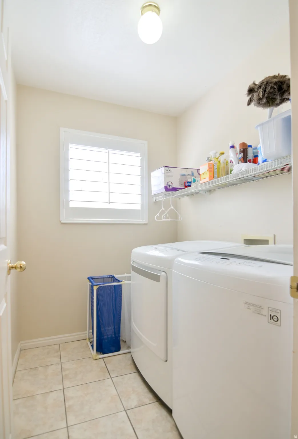 Laundry room featuring light tile patterned floors and separate washer and dryer