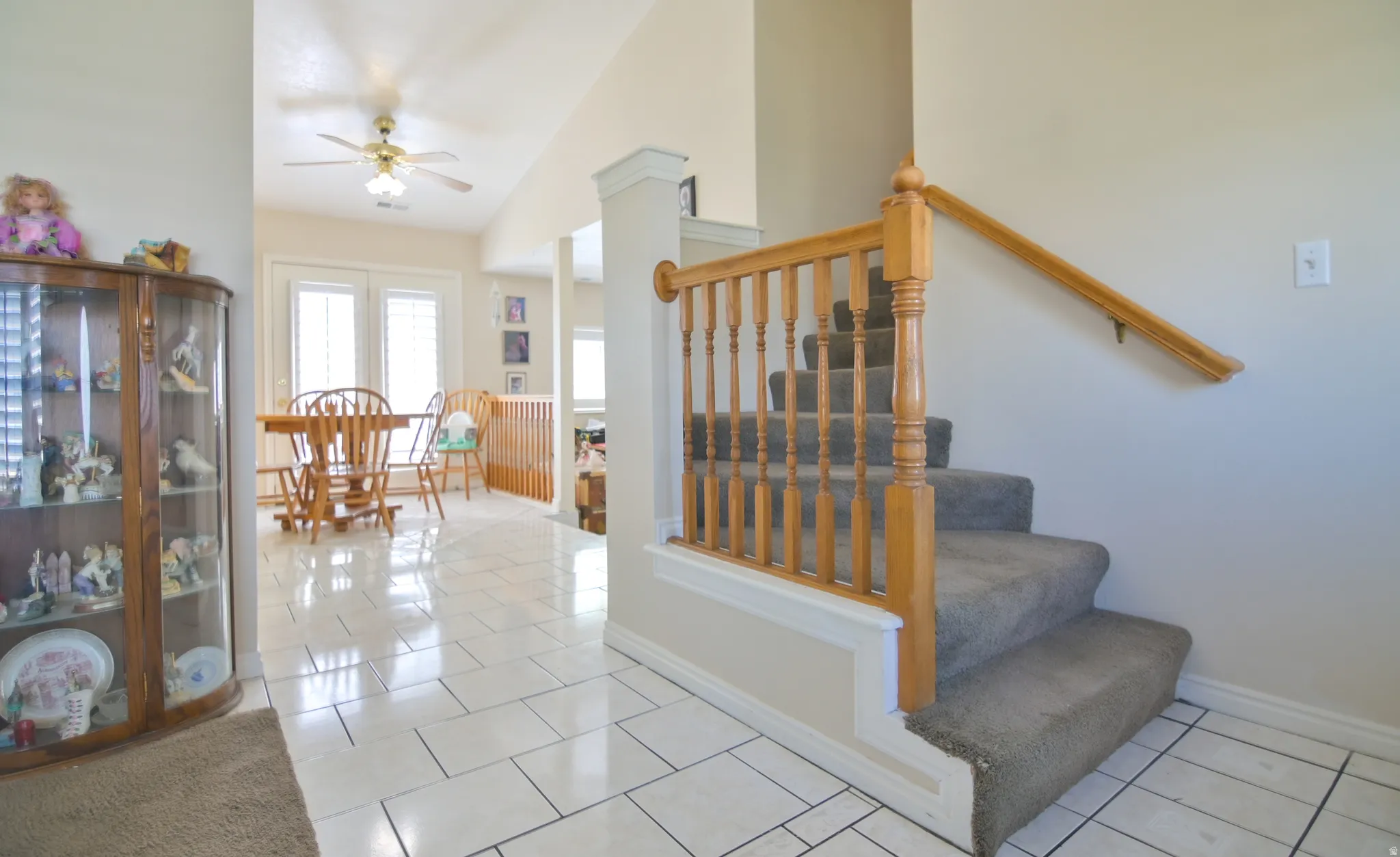 Staircase featuring tile patterned floors and ceiling fan