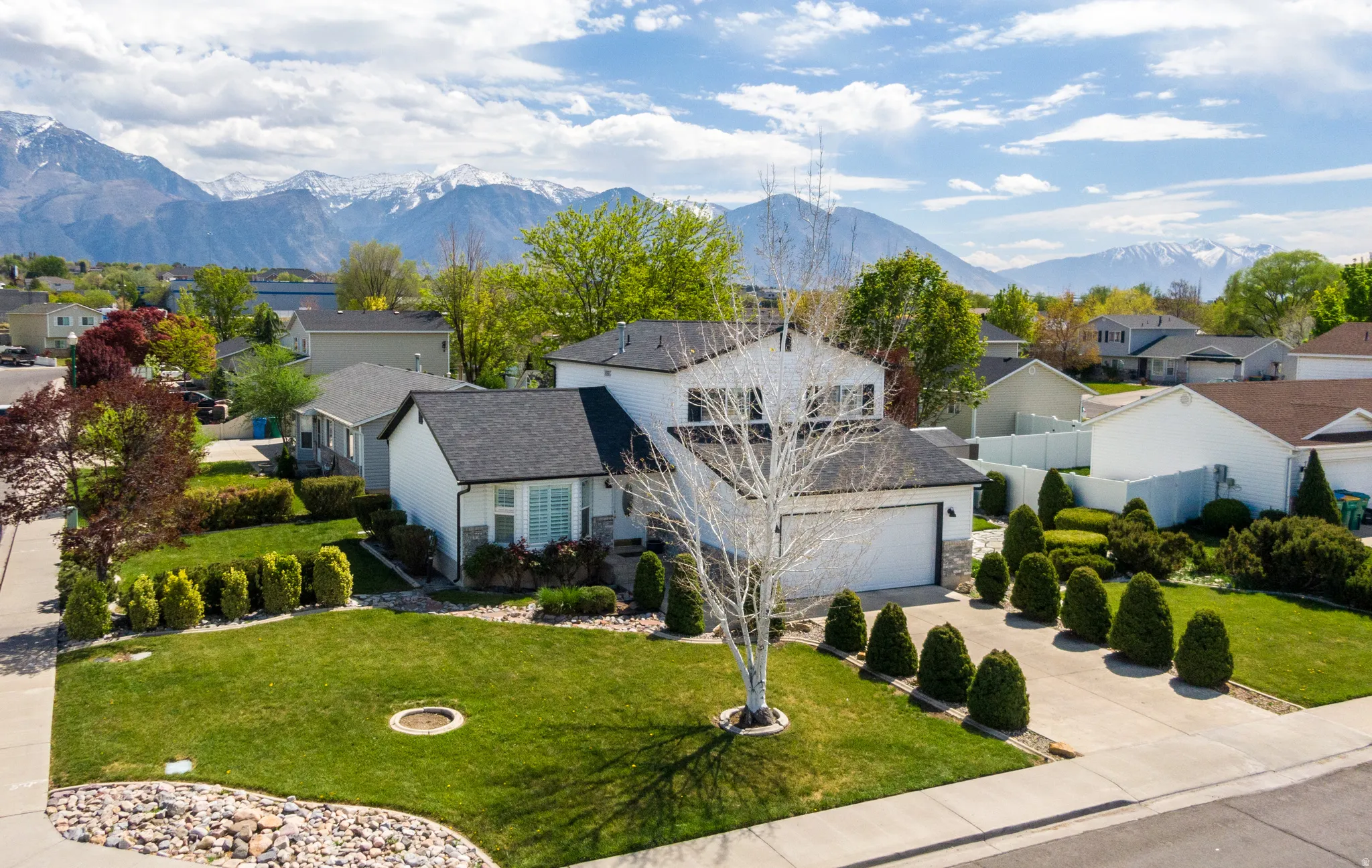 View of front of house with a residential view, concrete driveway, a mountain view, and a garage