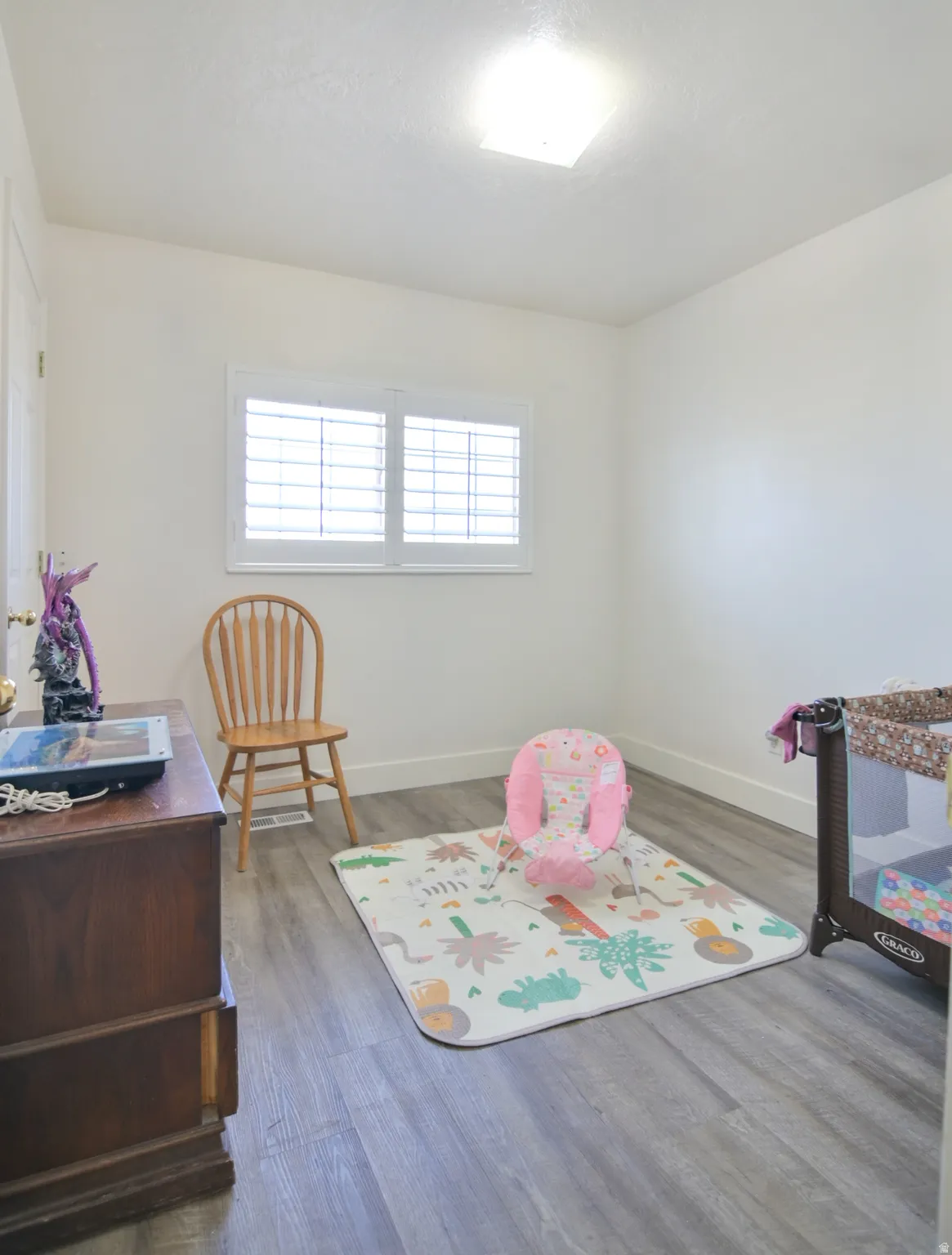 Playroom with baseboards and dark wood-style flooring