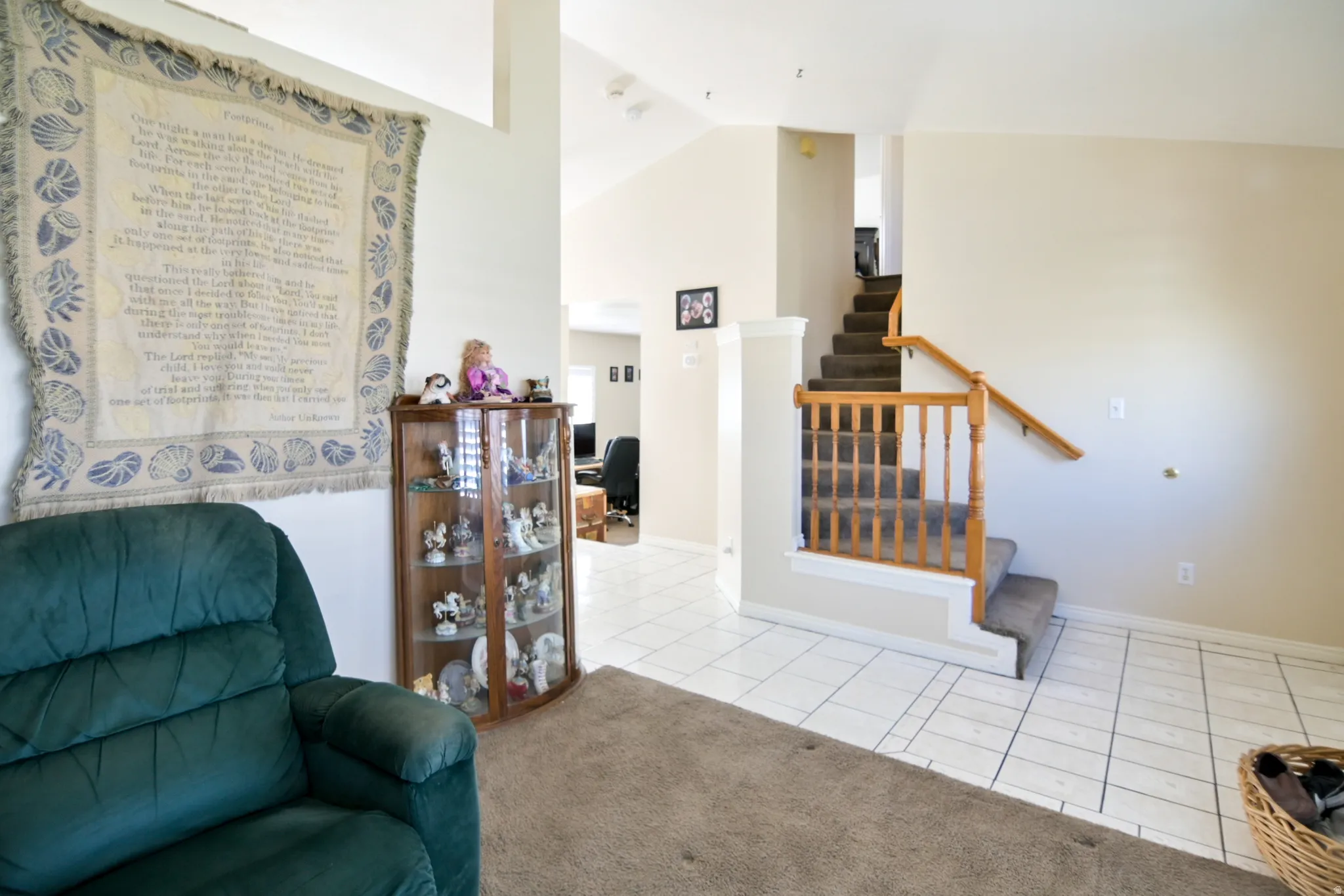 Sitting room with light tile patterned flooring, vaulted ceiling, and light carpet