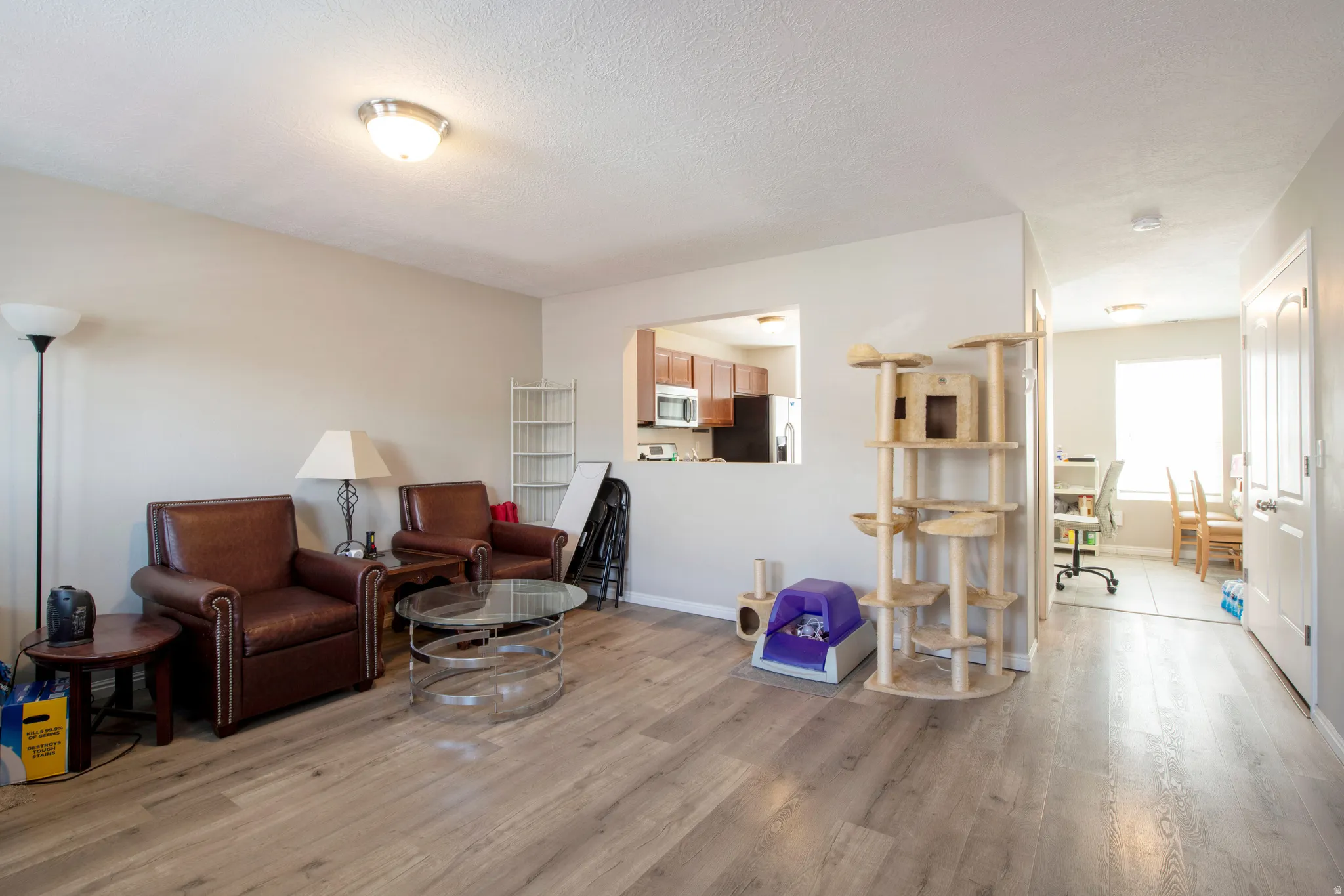 Living area featuring light wood-type flooring and a textured ceiling