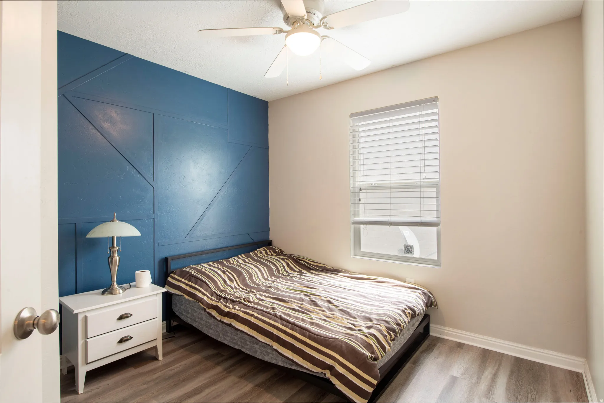 Bedroom with wood finished floors and a ceiling fan