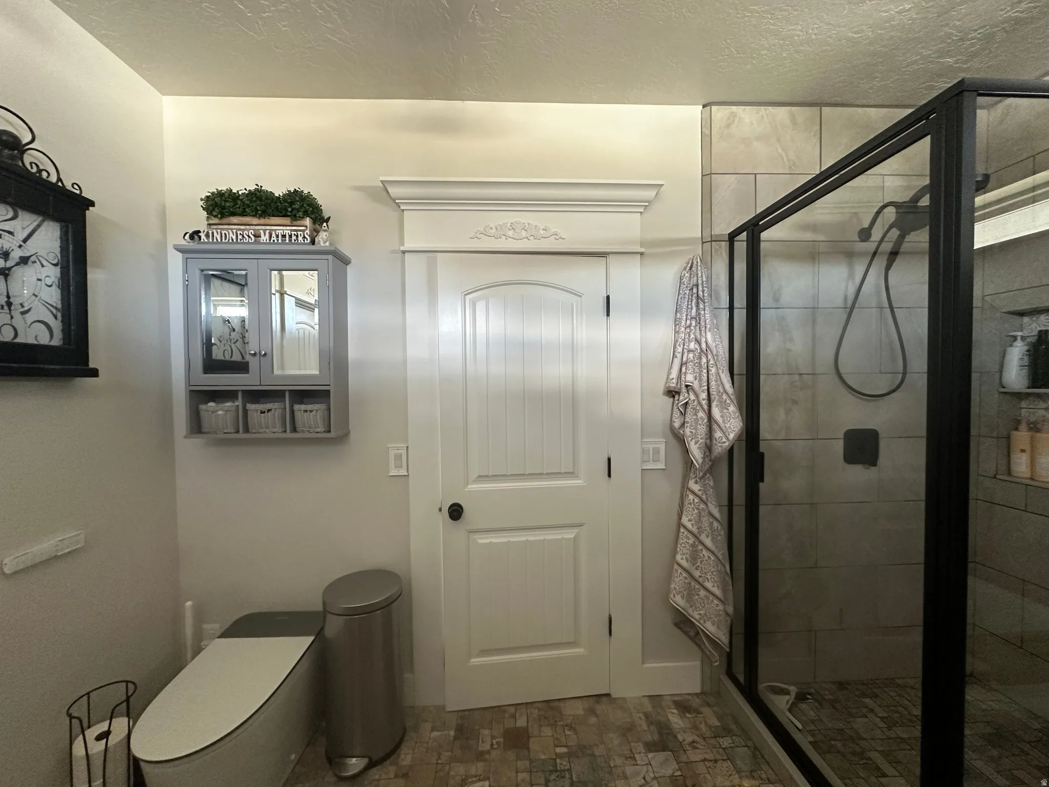 Bathroom featuring a stall shower and a textured ceiling