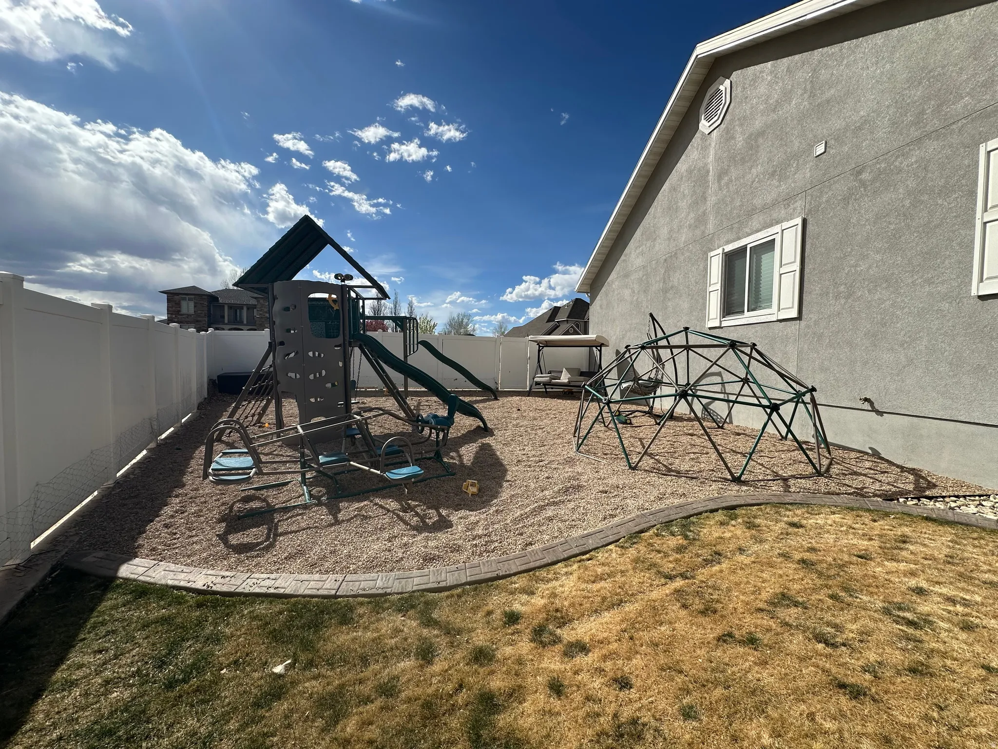 View of jungle gym with a fenced backyard