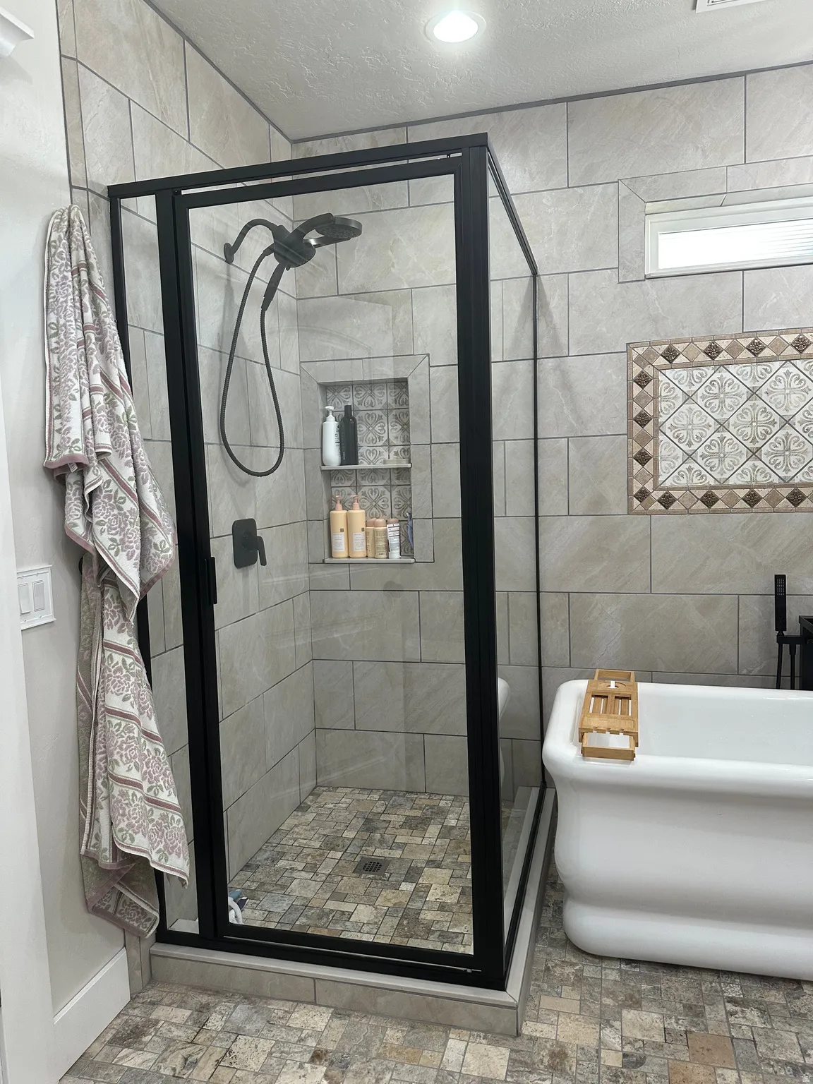 Full bathroom with a stall shower, a soaking tub, and a textured ceiling