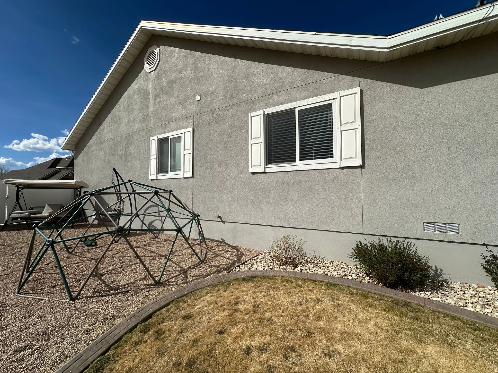 View of side of property featuring stucco siding and a playground