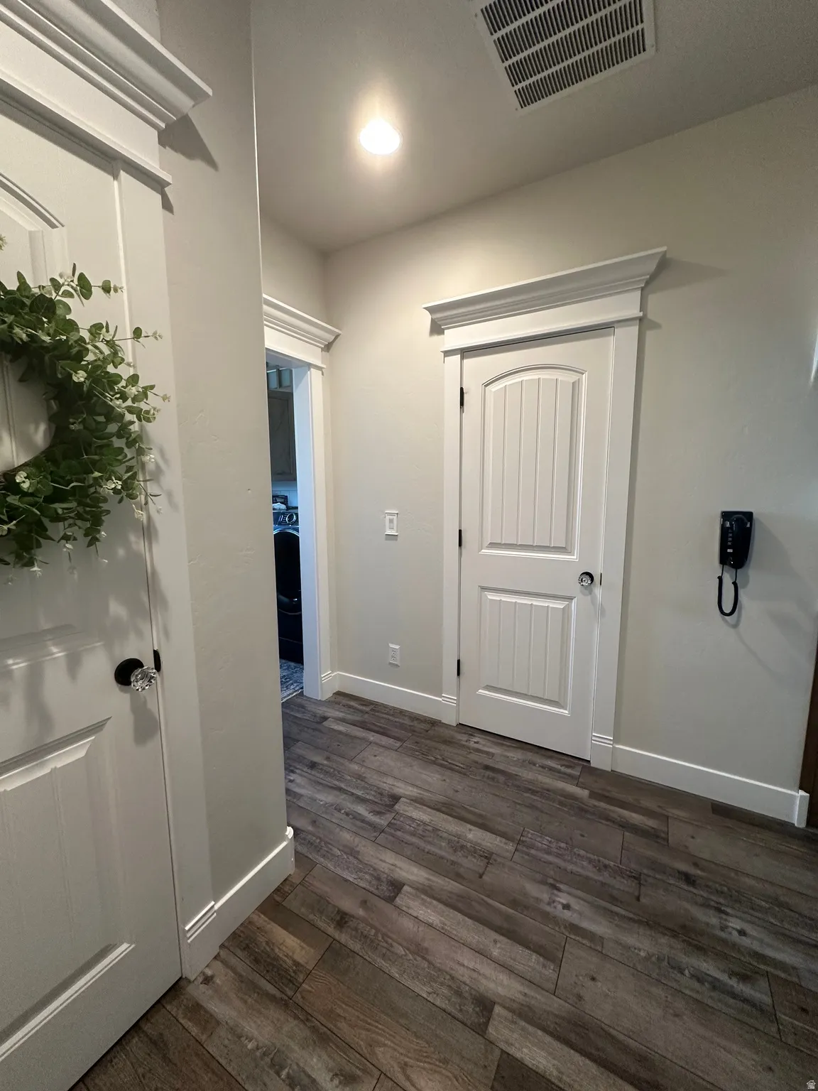 Corridor featuring dark wood-type flooring and baseboards