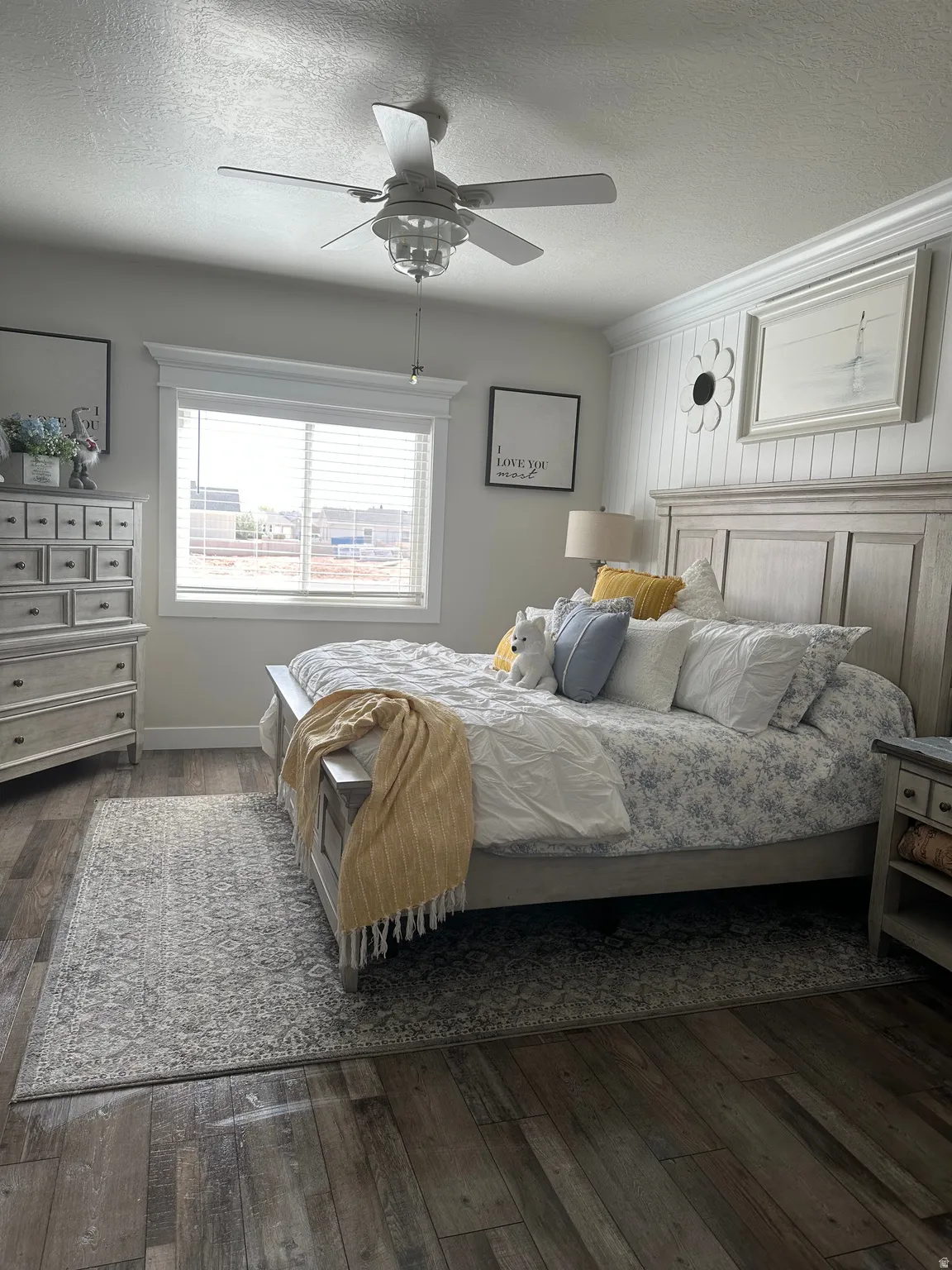Bedroom featuring a textured ceiling, dark wood-style floors, and a ceiling fan