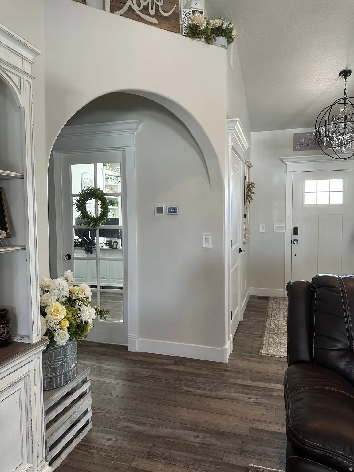 Entrance foyer with dark wood-type flooring and a chandelier