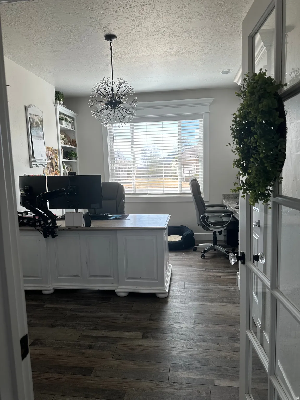 Office area with dark wood-style flooring, a textured ceiling, and hanging lights