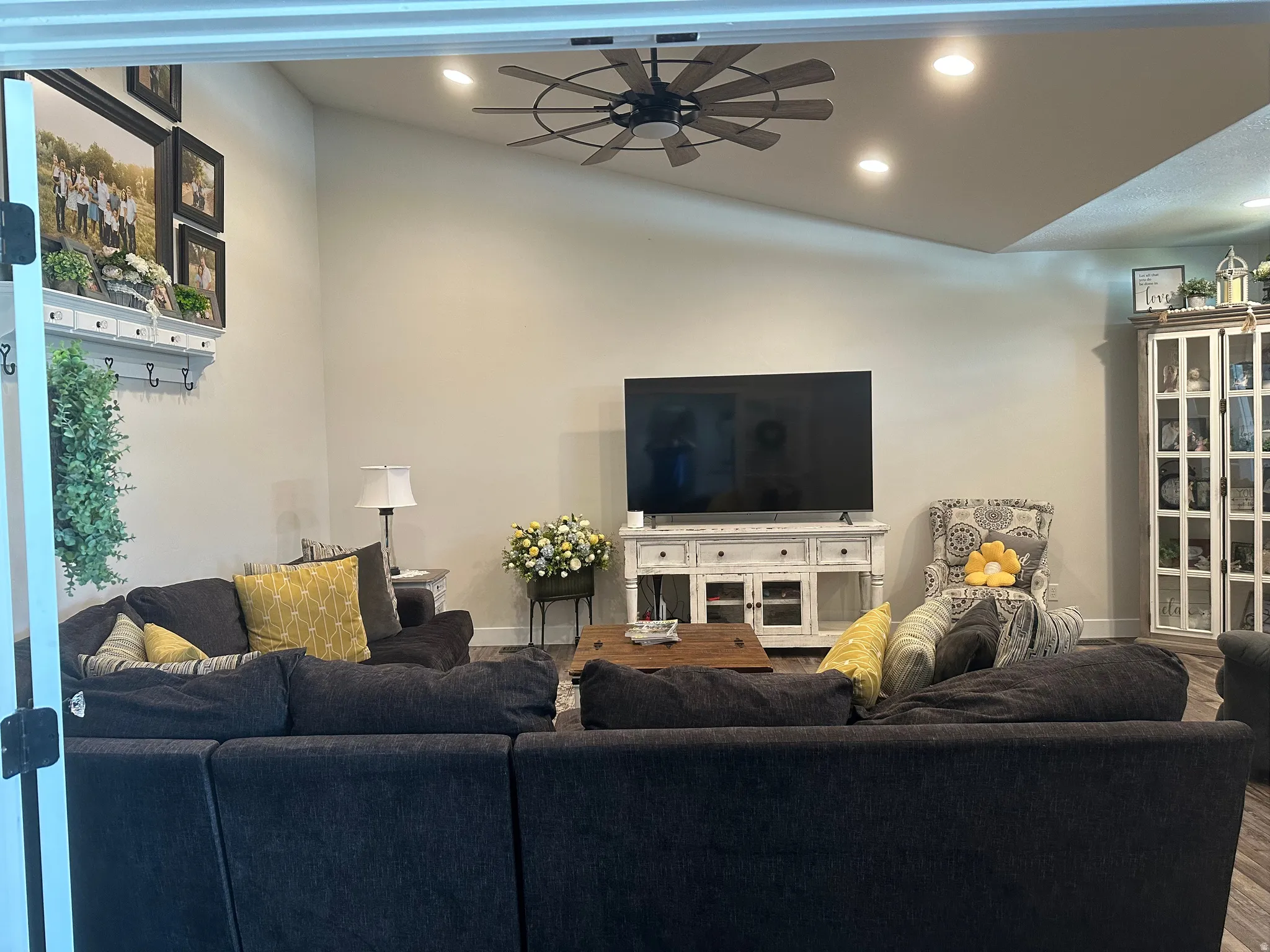 Living room featuring a ceiling fan, recessed lighting, wood finished floors, and vaulted ceiling