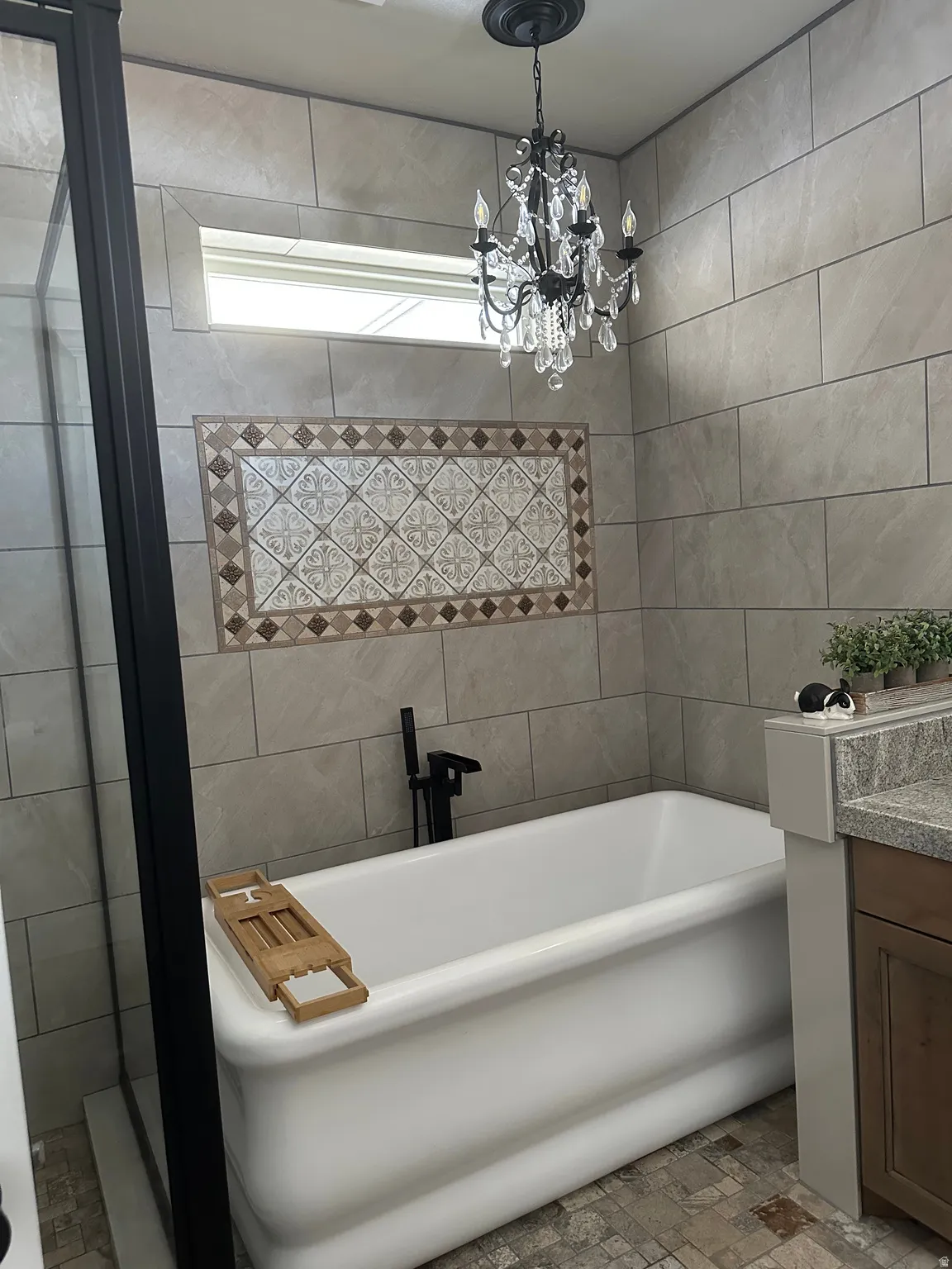 Bathroom with vanity, a soaking tub, and hanging lights