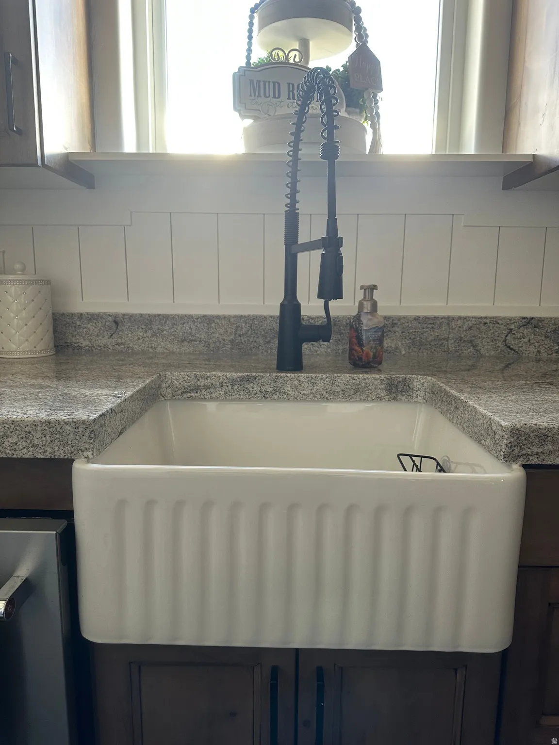 Kitchen view of a sink and white cabinets