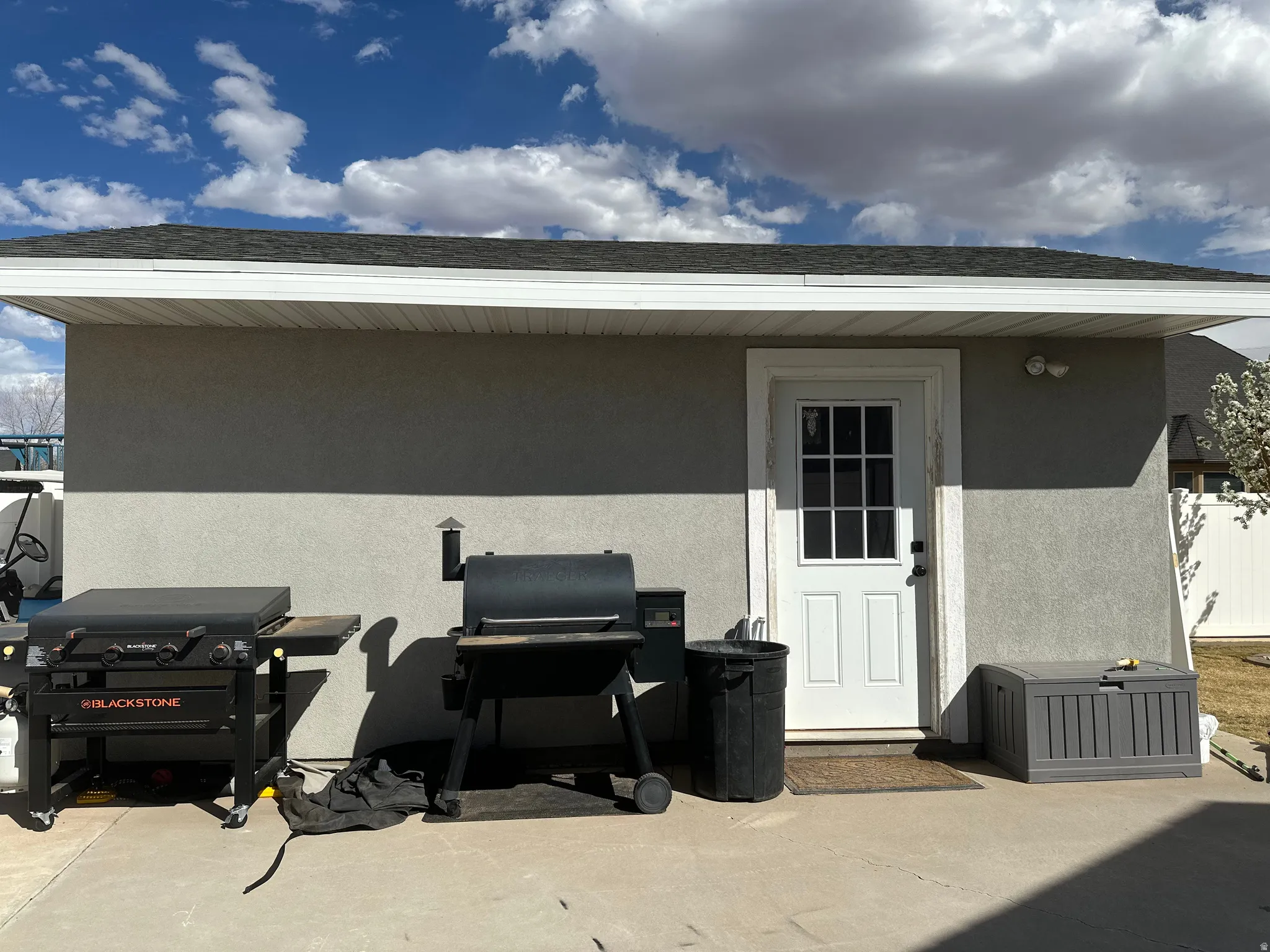 Rear view of property featuring stucco siding, a patio area, and roof with shingles