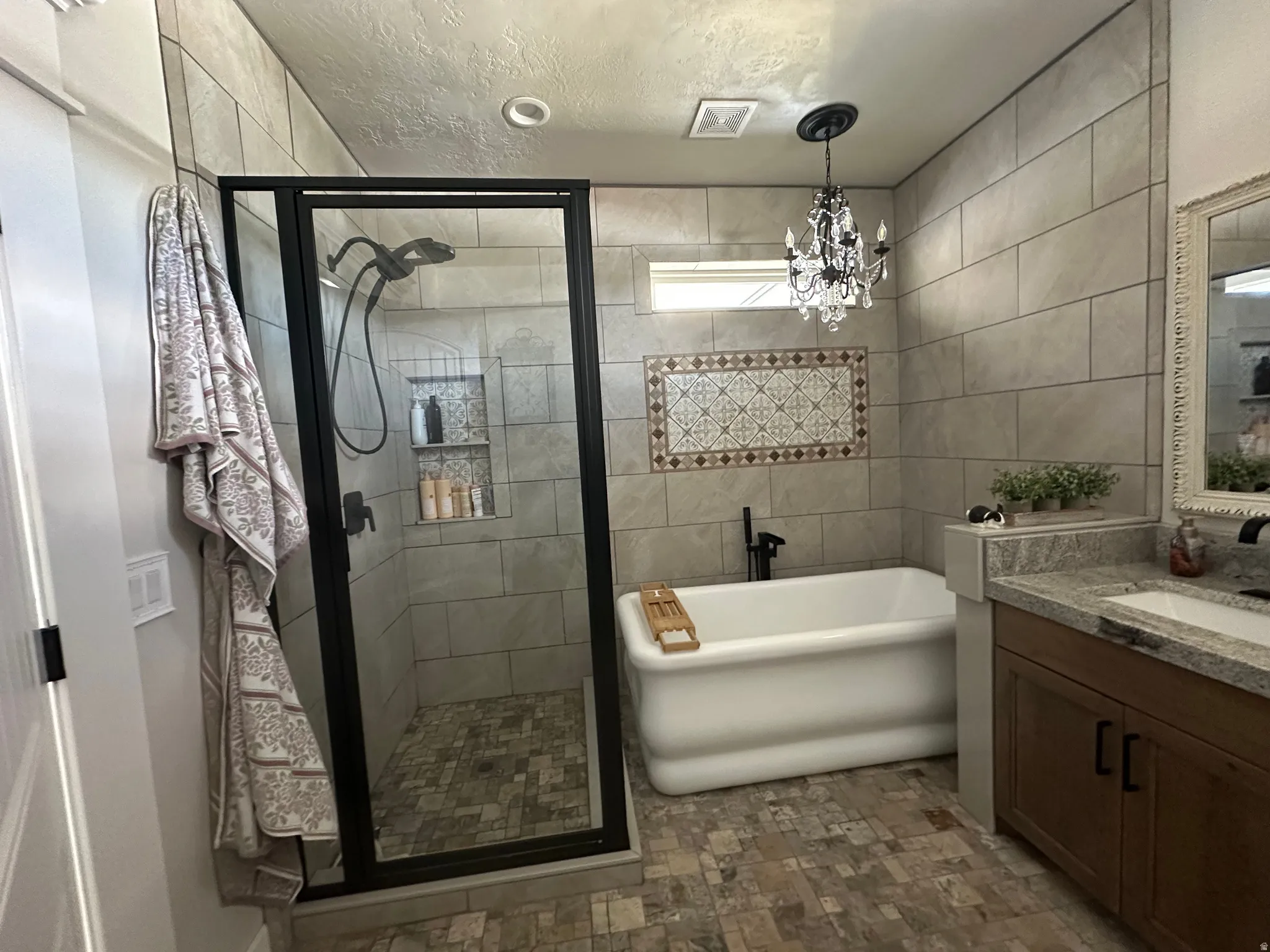 Bathroom featuring a stall shower, vanity, a freestanding bath, and a textured ceiling
