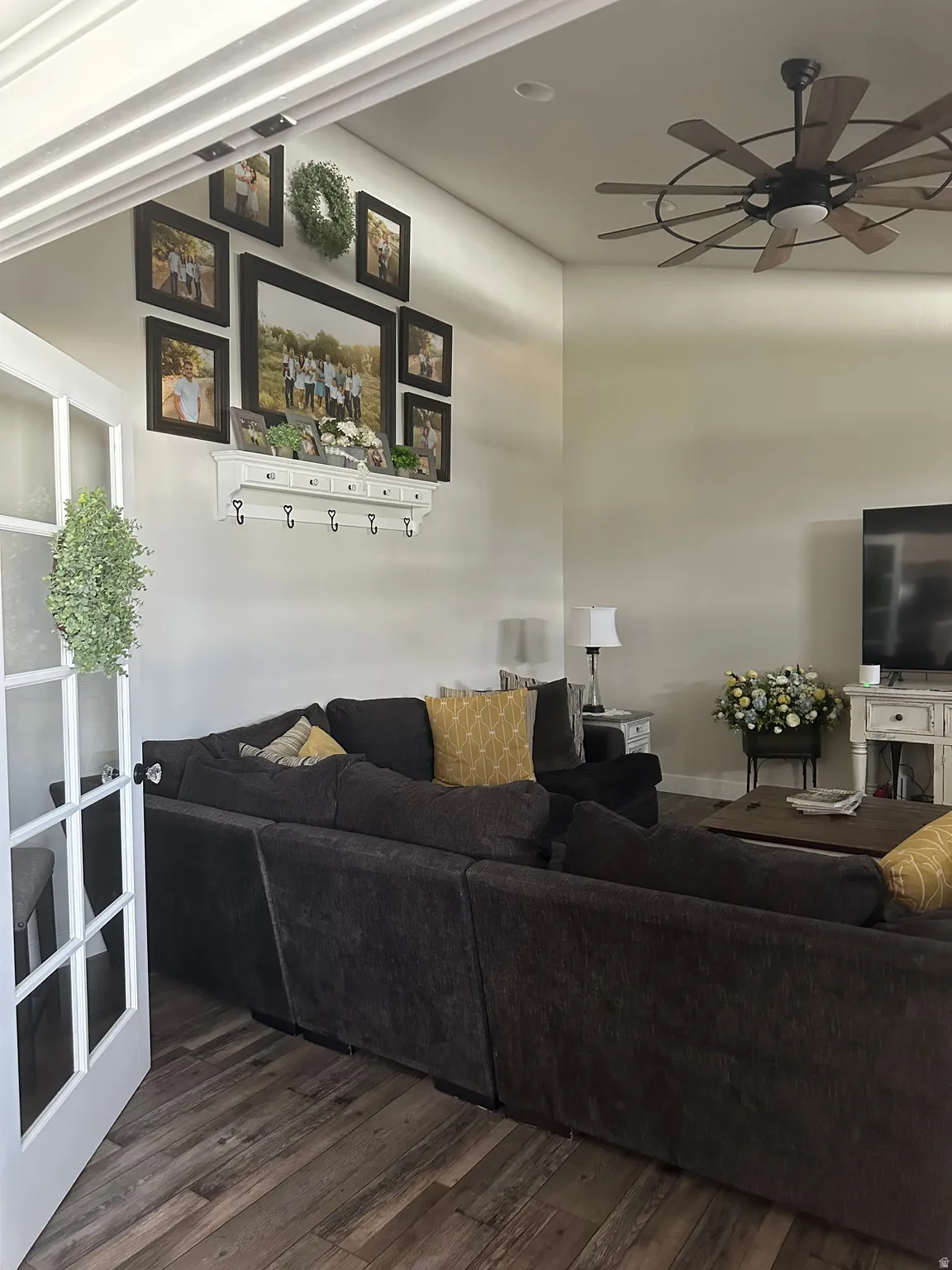 Living room featuring ceiling fan and dark wood-type flooring