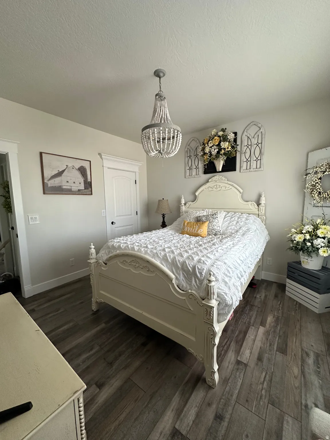 Bedroom featuring dark wood finished floors, a textured ceiling, and suspended lighting