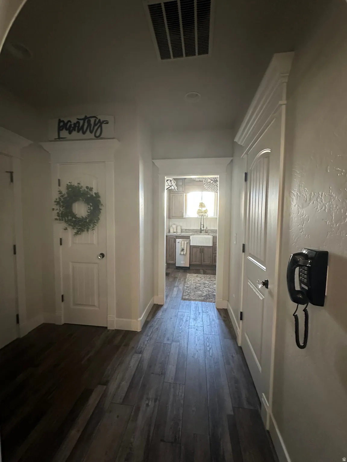 Corridor featuring baseboards and dark wood-style flooring