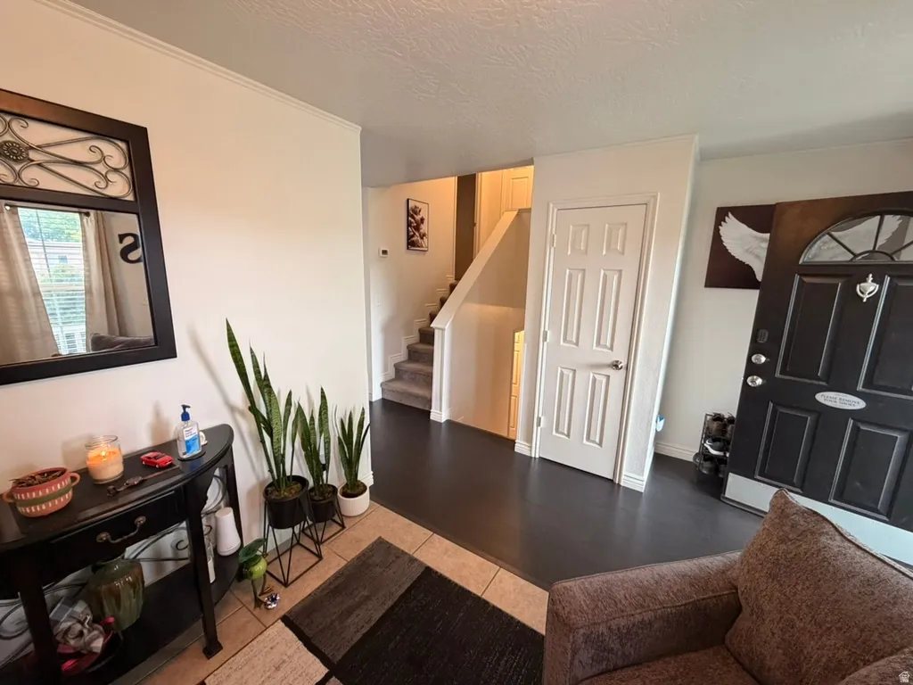 Entrance foyer with stairs and a textured ceiling