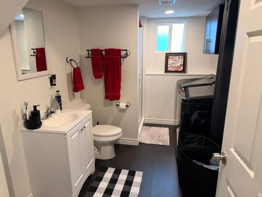 Bathroom with vanity, a shower with shower curtain, and dark wood finished floors