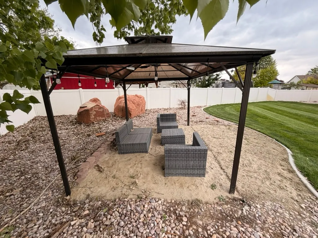 Fenced backyard featuring a patio area, outdoor furniture, and a gazebo