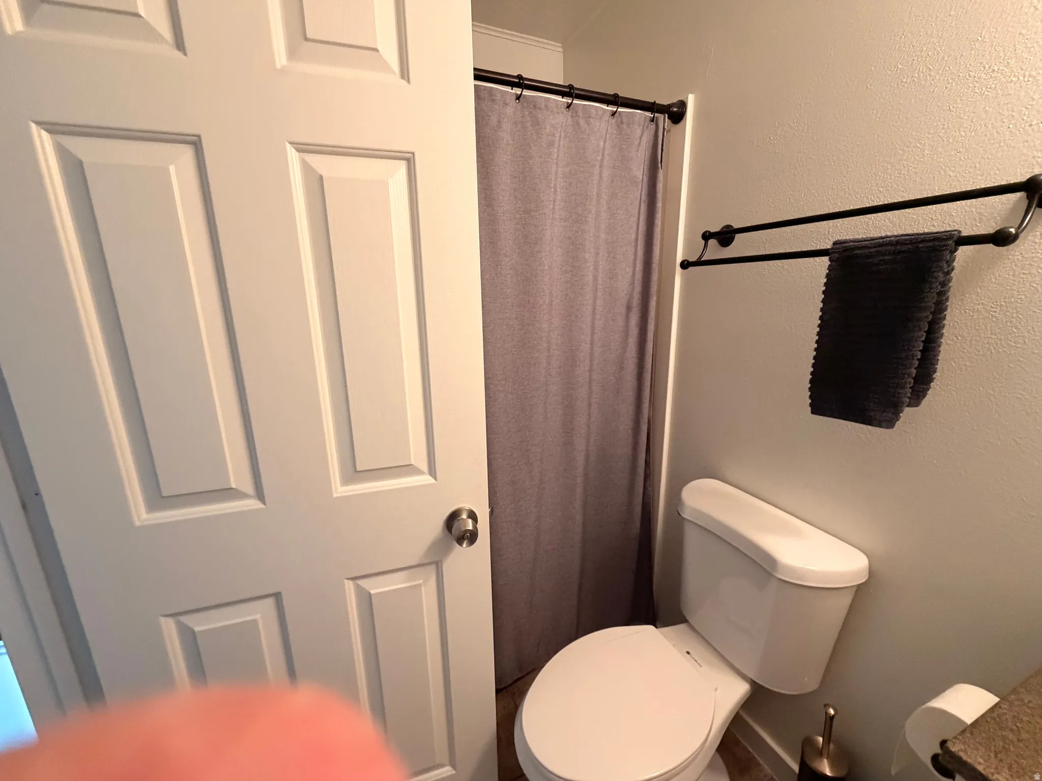 Bathroom featuring curtained shower and a textured wall