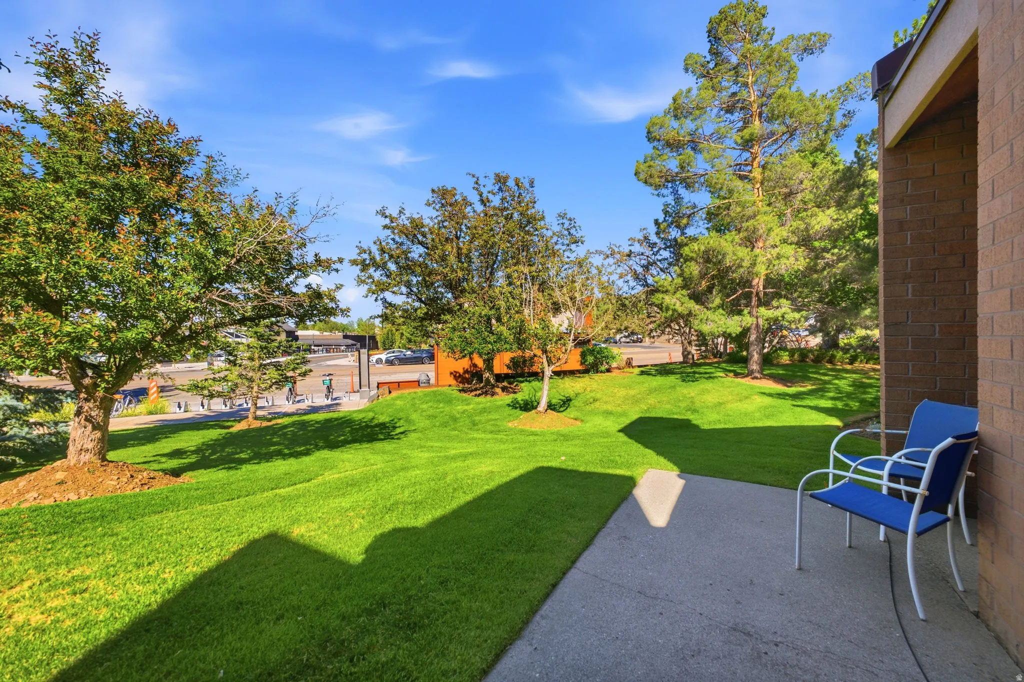 Private patio area with concrete flooring, bordered by a substantial grassy expanse