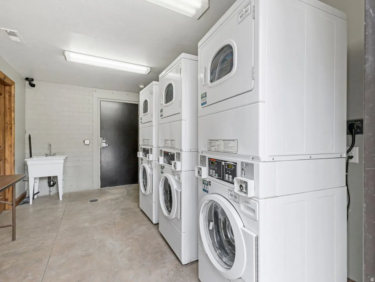 Communal laundry room with stacked washer / dryer and washing machine and clothes dryer