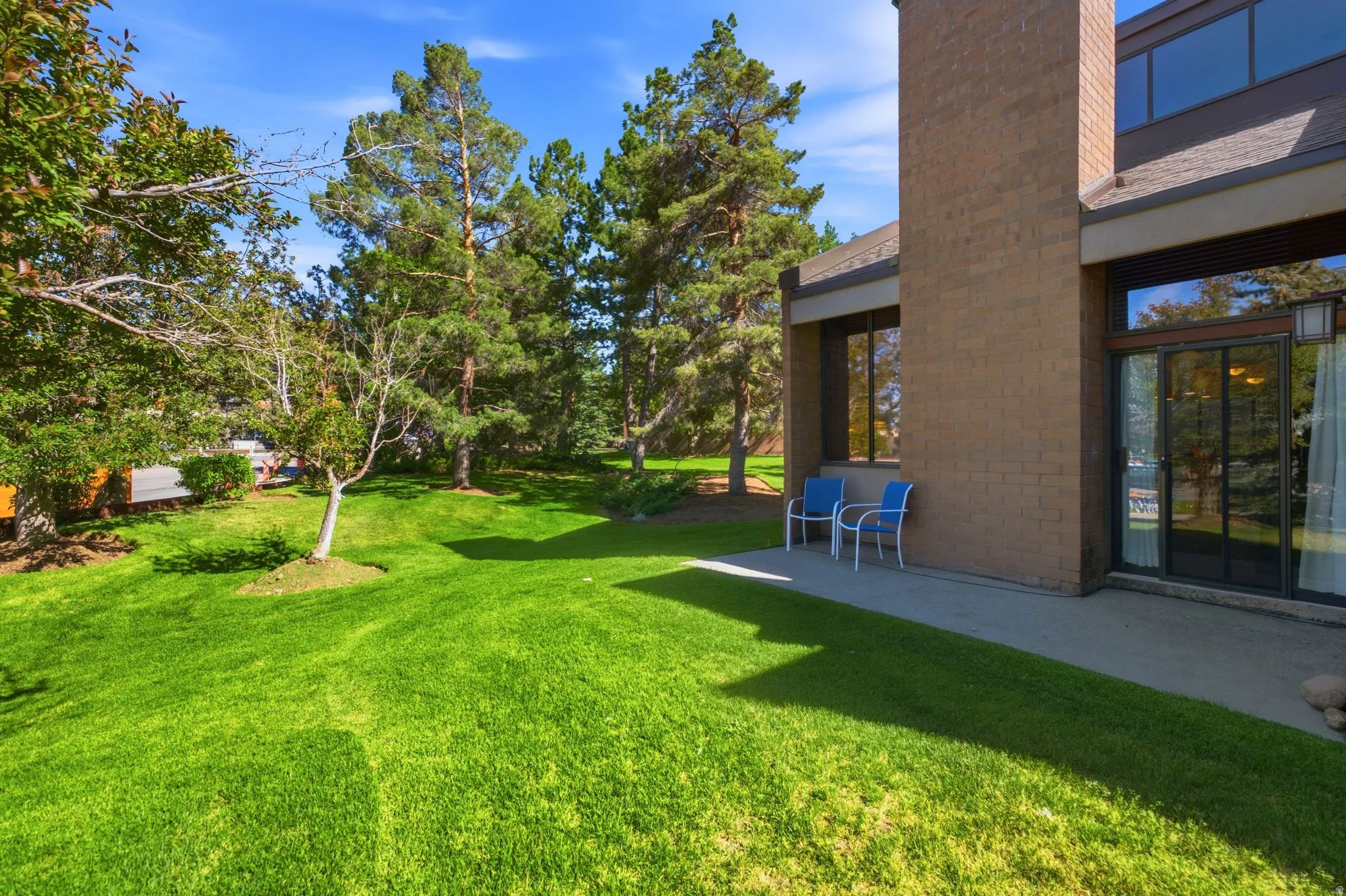 Expansive green lawn with mature trees bordering the property