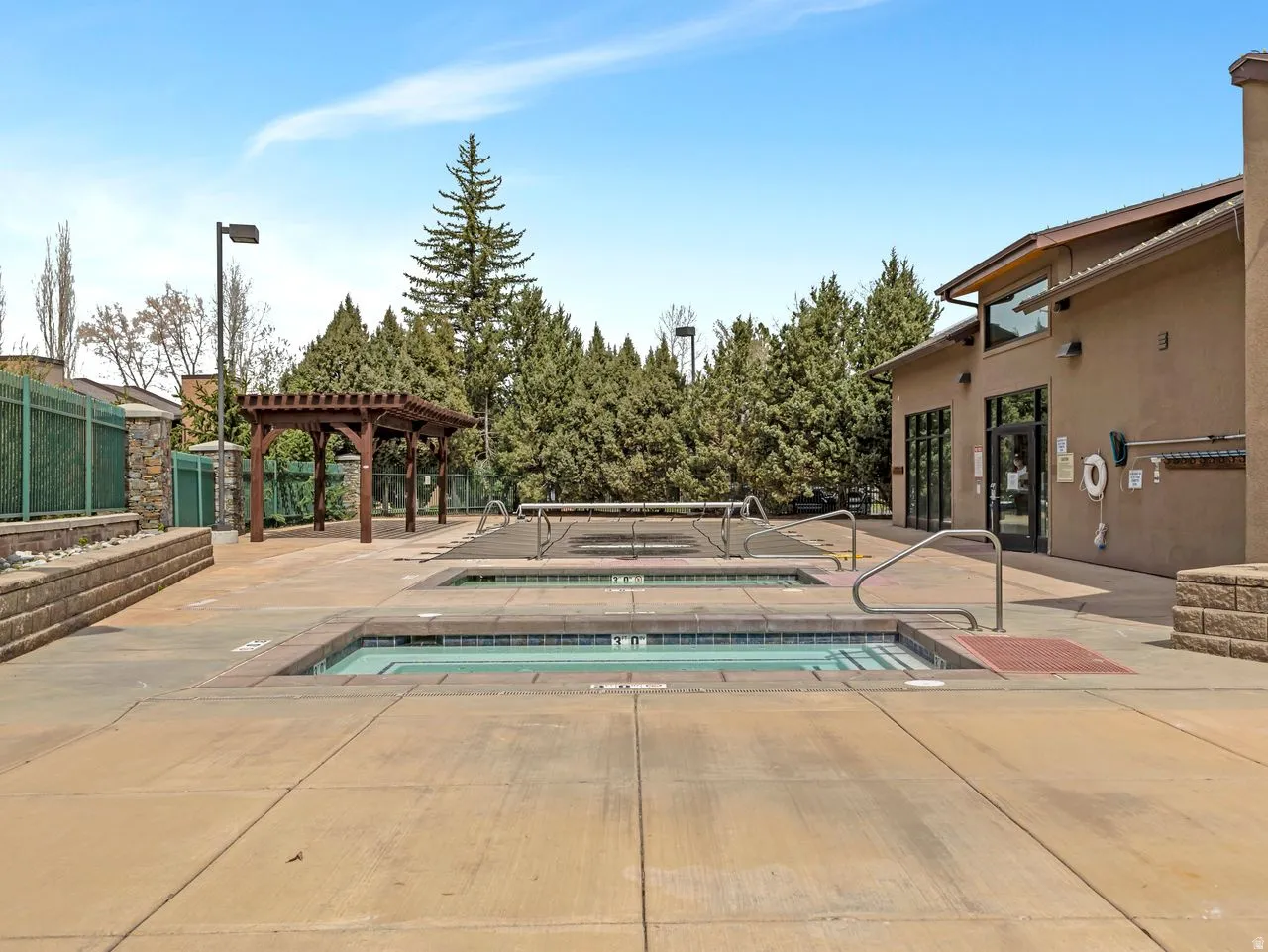View of swimming pool featuring a jacuzzi, a pergola, and patio surround
