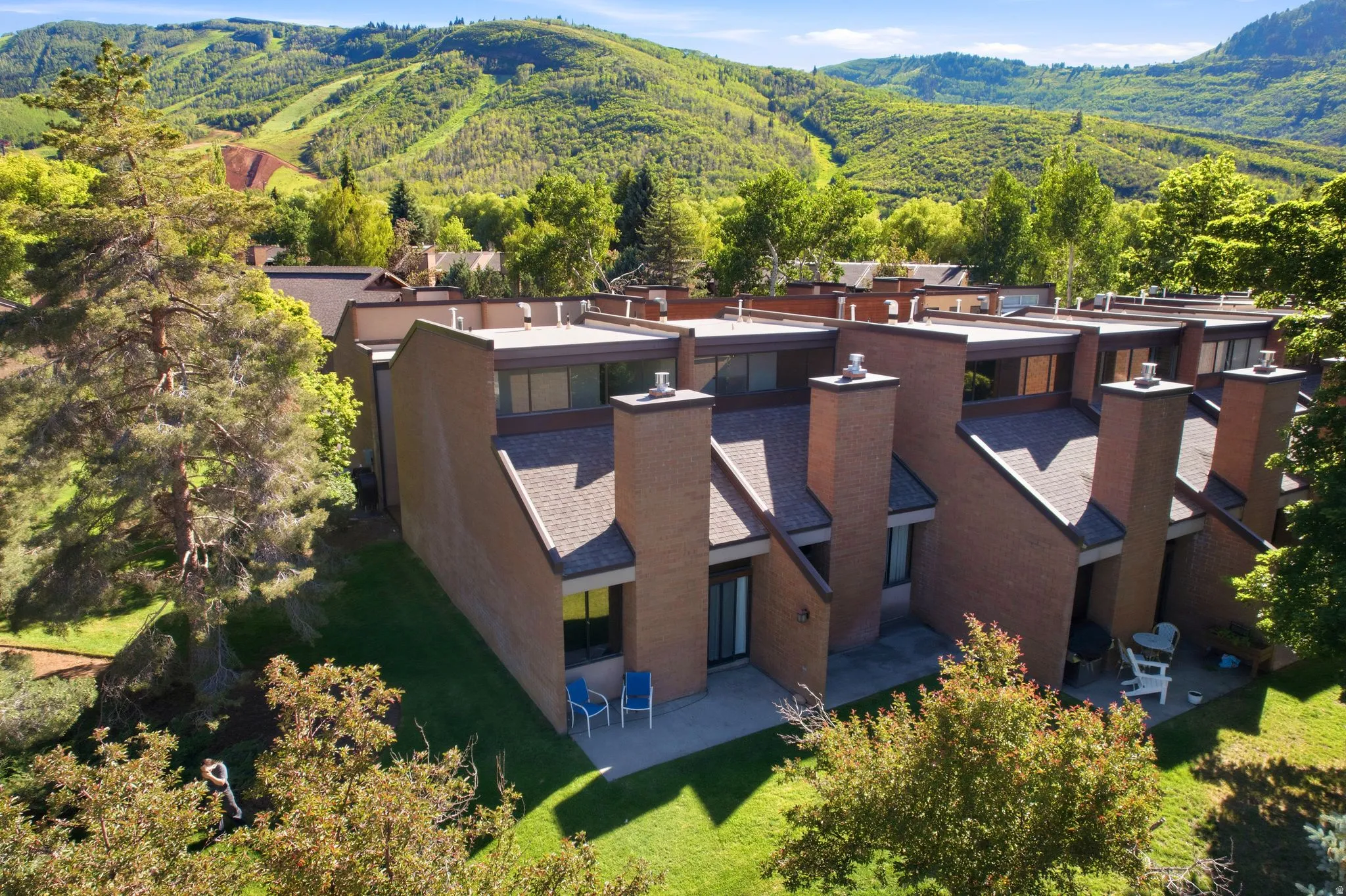 Terraced townhome-style residences featuring brick exteriors, pitched roofs, and individual patios