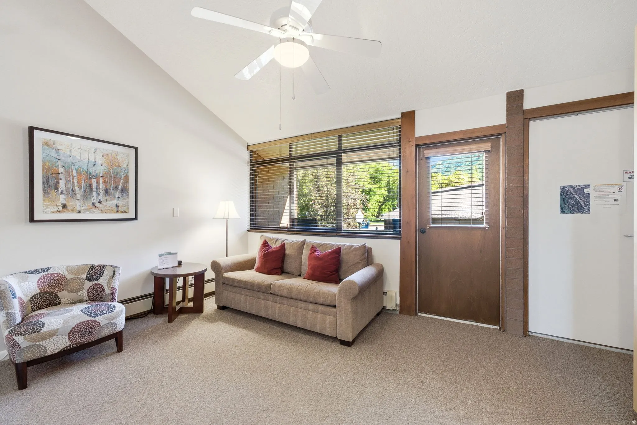 Living area featuring a vaulted ceiling and an overhead ceiling fan