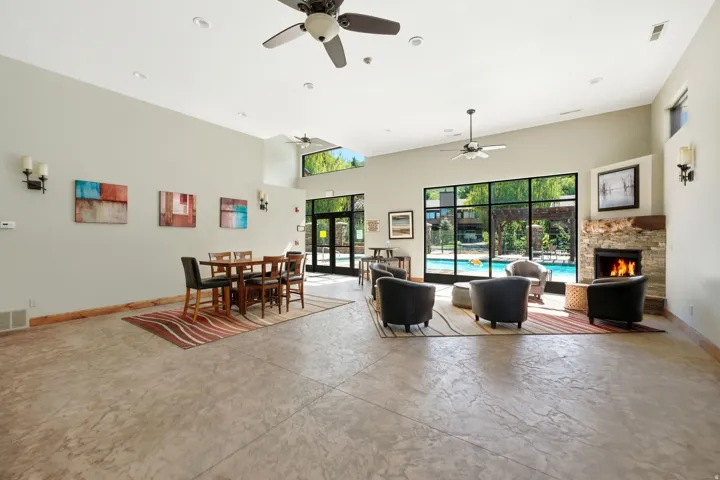Spacious common area featuring an expansive fireplace with stacked stone surround, large transom windows, and durable patterned flooring