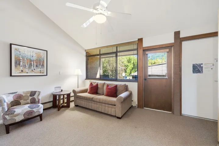 Living area featuring a vaulted ceiling and an overhead ceiling fan