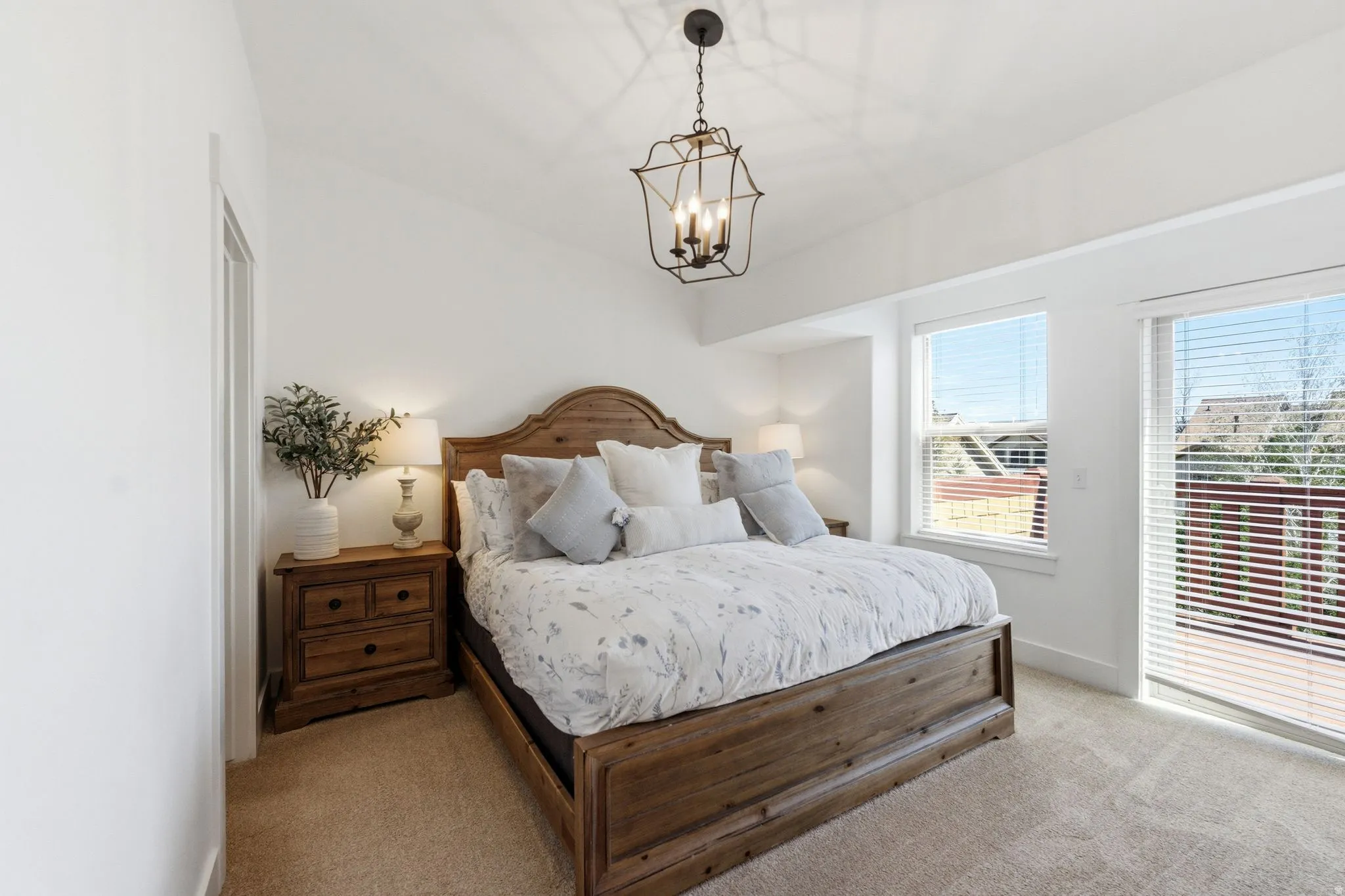 Carpeted bedroom featuring baseboards and hanging lights