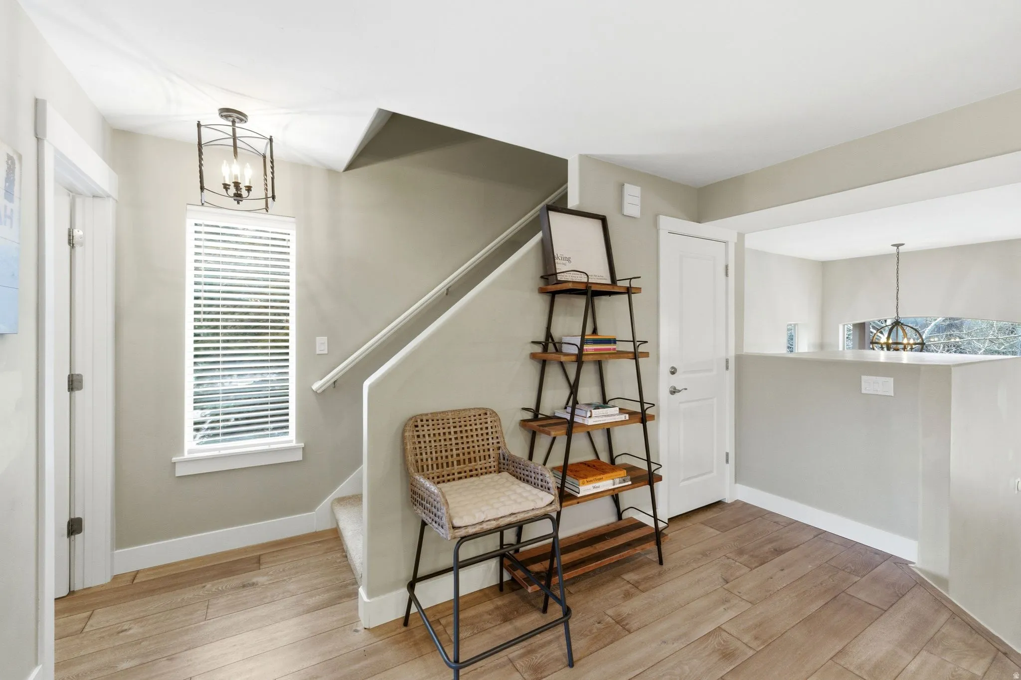 Sitting room with hanging lights and light wood-style floors