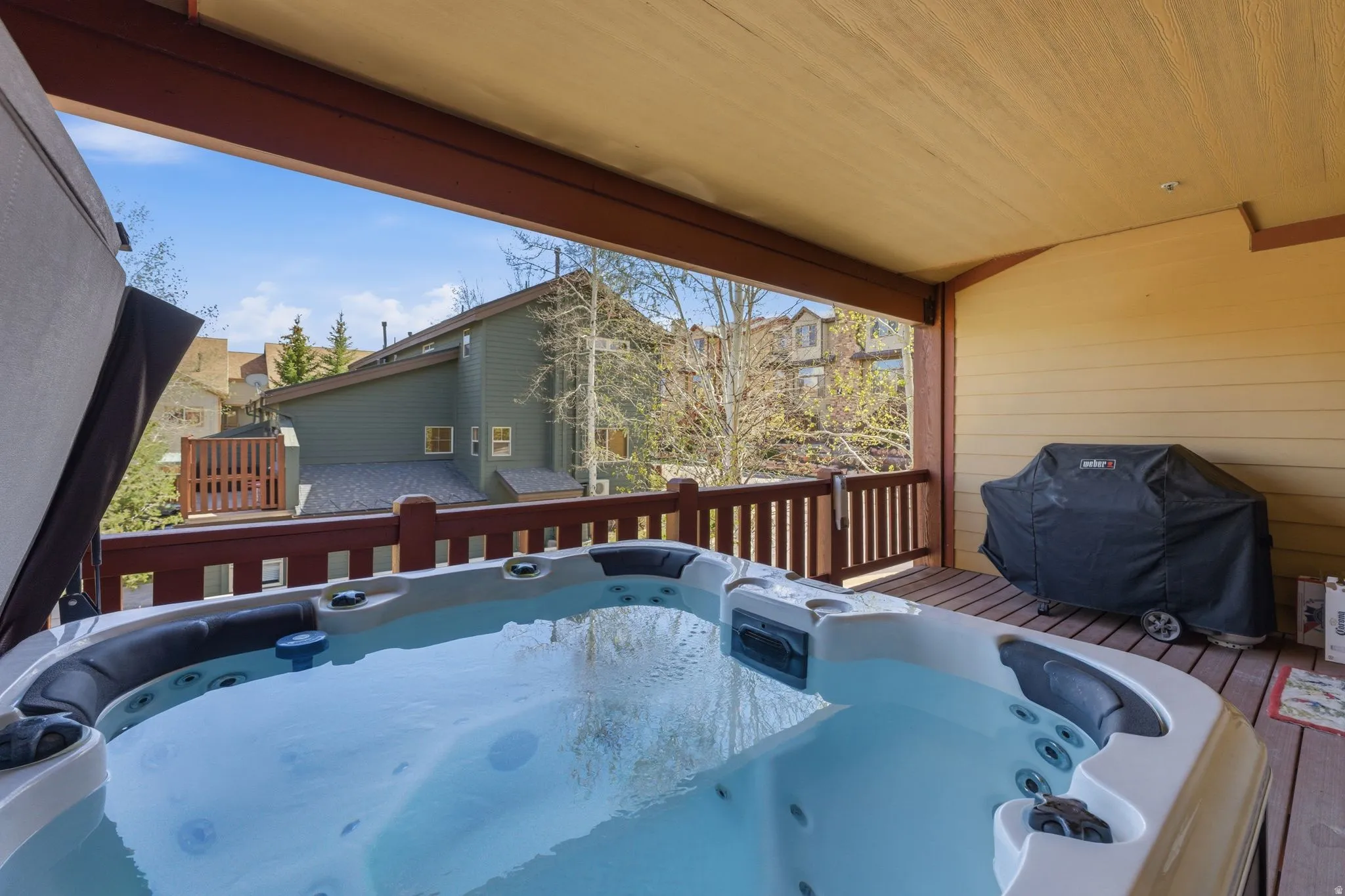 Wooden deck with a hot tub and grilling area