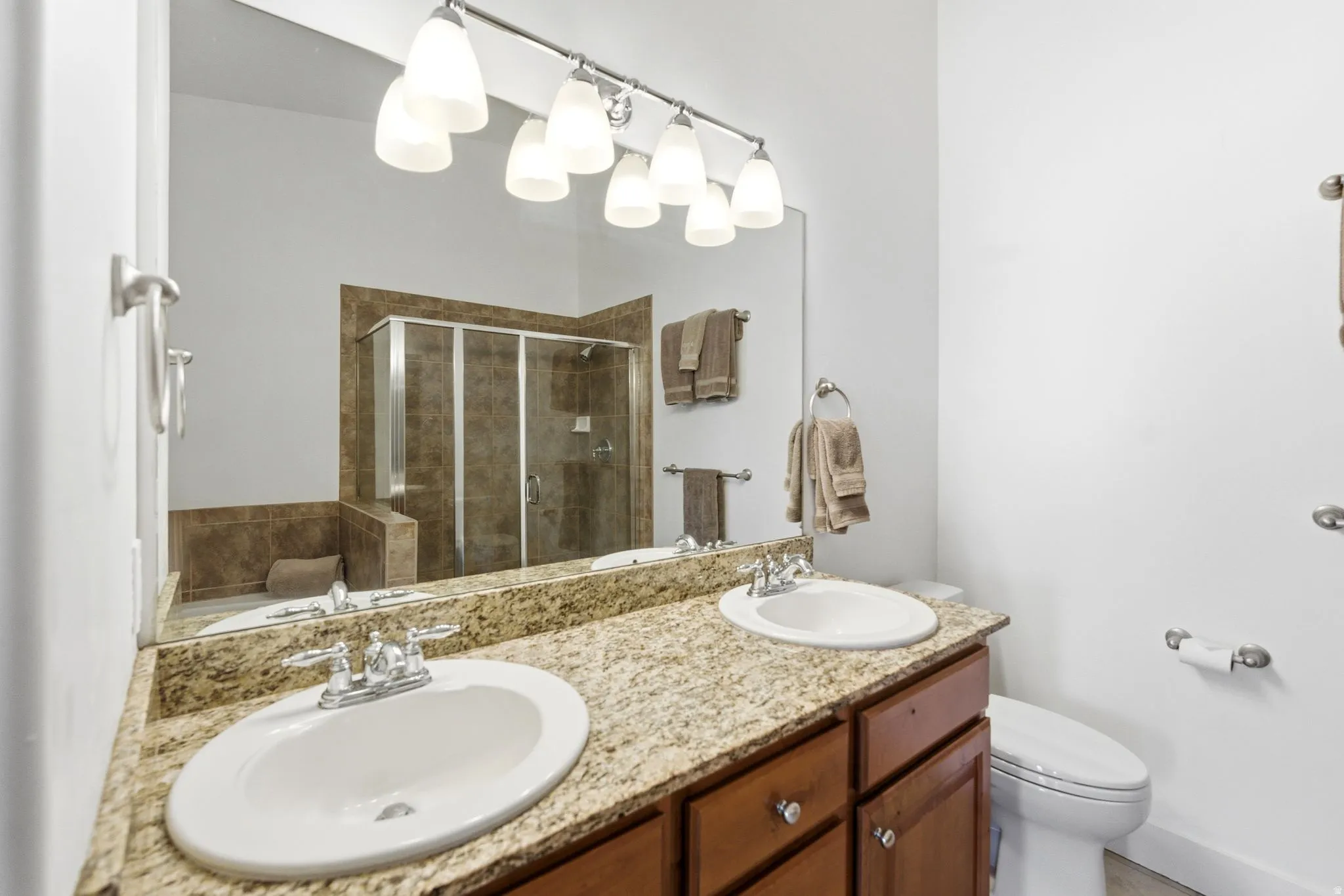 Full bathroom featuring double vanity, a stall shower, and a bath