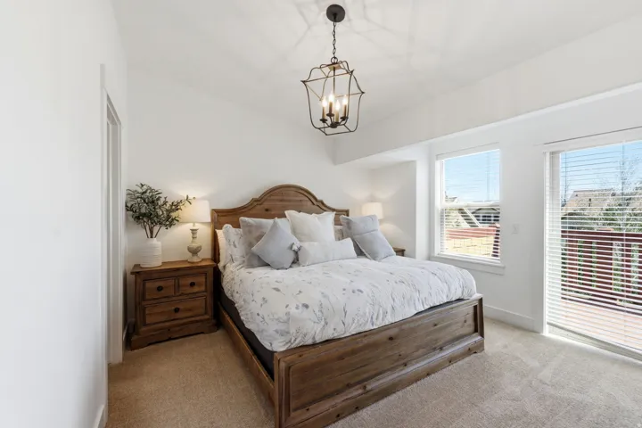 Carpeted bedroom featuring baseboards and hanging lights