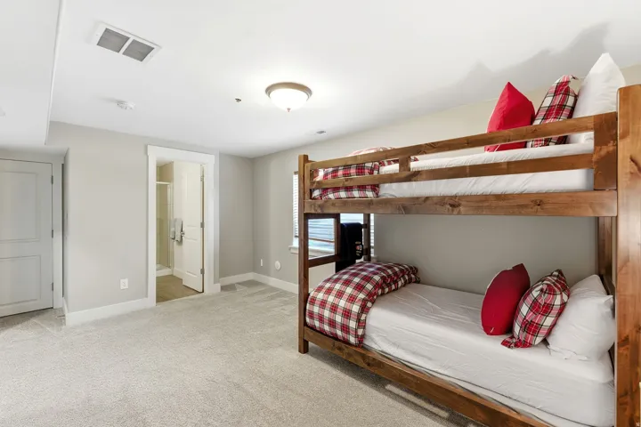 Bedroom with light colored carpet and ensuite bathroom