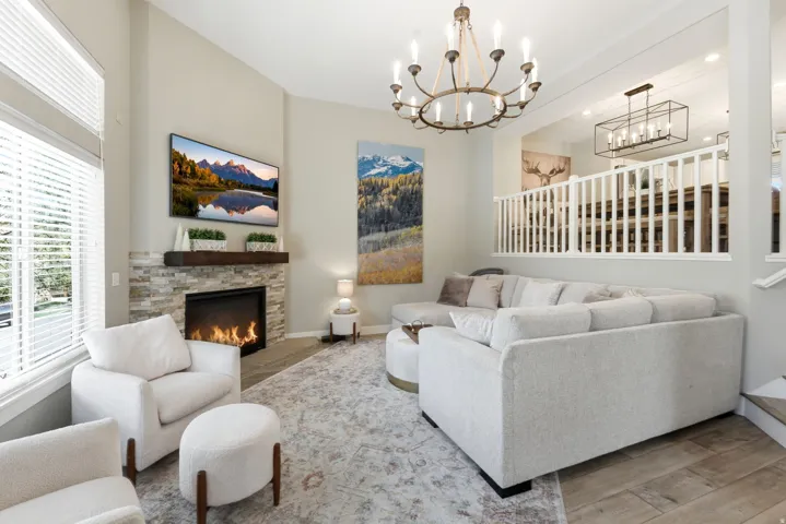 Living area featuring a fireplace, wood finished floors, and suspended lighting