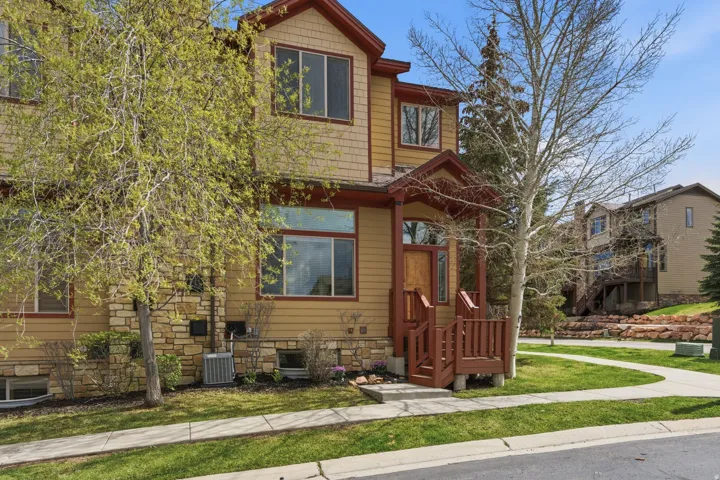 View of front of property with a front yard and stone siding